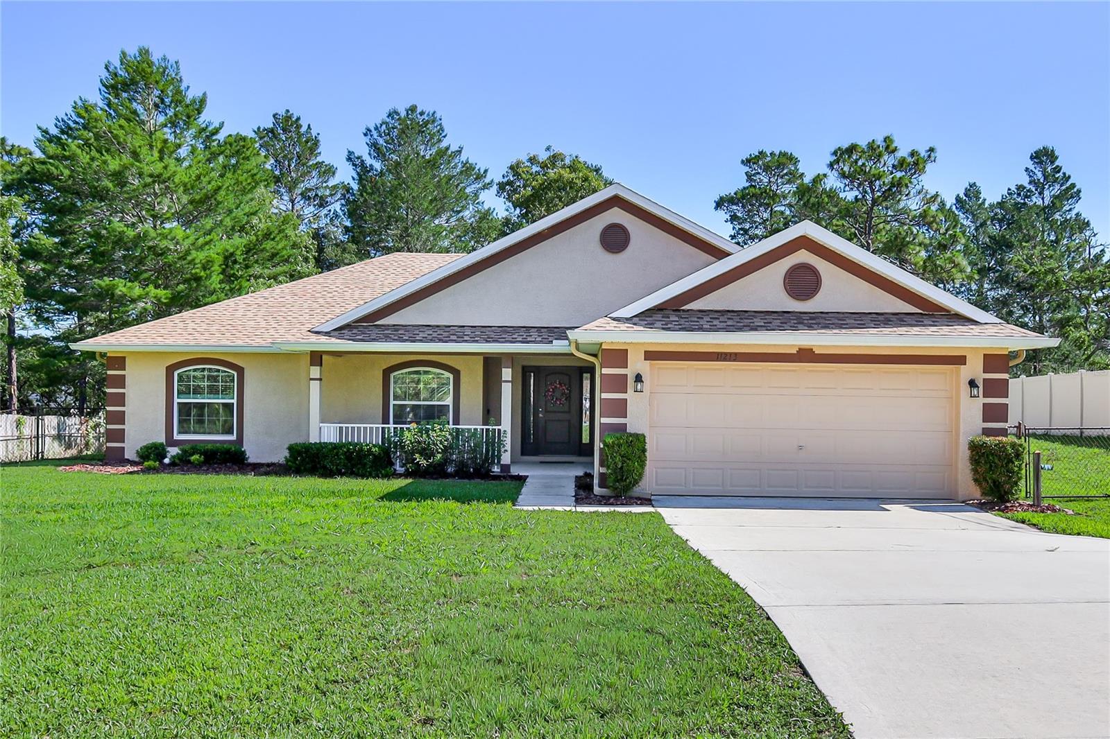 Beautiful, updated 4/2/2 with NO HOA DUES AND NO CDD FEES, situated on .46 acres  & fully fenced. Original owner and very well cared for is obvious when you view it.
The front of the home has A lovely front porch to sit out and enjoy the Florida weather. Lovely entry takes you to the upgraded kitchen equipped with Maple Wood Cabinets that are Staggered and Bumped Out.  Newly upgraded Granite Counters, Subway Tile Backsplash and SS appliances.  Range has convection oven too!  The whole home has newer Luxury Vinyl Flooring.  Baseboard is 5” all around the home.  
Very large dining area is convenient to the kitchen and great room.  Open floor plan makes this home perfect for entertaining.
Door leading to the guest suite with 2 bedrooms and full bath providing ultimate Privacy.  4th bedroom can be home office as well. Primary bedroom with view of the yard has on suite with walk-in shower,  double vanities with granite counters, soaking tub and walk-in closet.  Guest bath also upgraded with granite counter.
Great room has vaulted ceiling and is big and comfy. Single French Door leads to oversized screened in lanai.  The screen is a Privacy Screen which means it has UV Protection and offers privacy in that others cannot see you on the lanai.  The lanai overlooks a large open yard with plenty of room for pool, veggie garden, play set and more. The exterior shed is useful for tools and equipment. Inside Oversized Utility Room with shelving for storage. 

A private well and septic system, eliminating water and sewer bills, includes an irrigation system, gutters & downspouts surround the home. This is an awesome location near shopping, restaurants, schools, and medical facilities, Suncoast Parkway direct to Tampa & Weeki Wachee River for fishing and kayaking.
New roof on home and on shed 6/2025, Washer and  Dryer included – (’24 & ’25), Hot Water Heater 2 years young. Interior was just painted as well. Home qualifies for USDA Loan.
