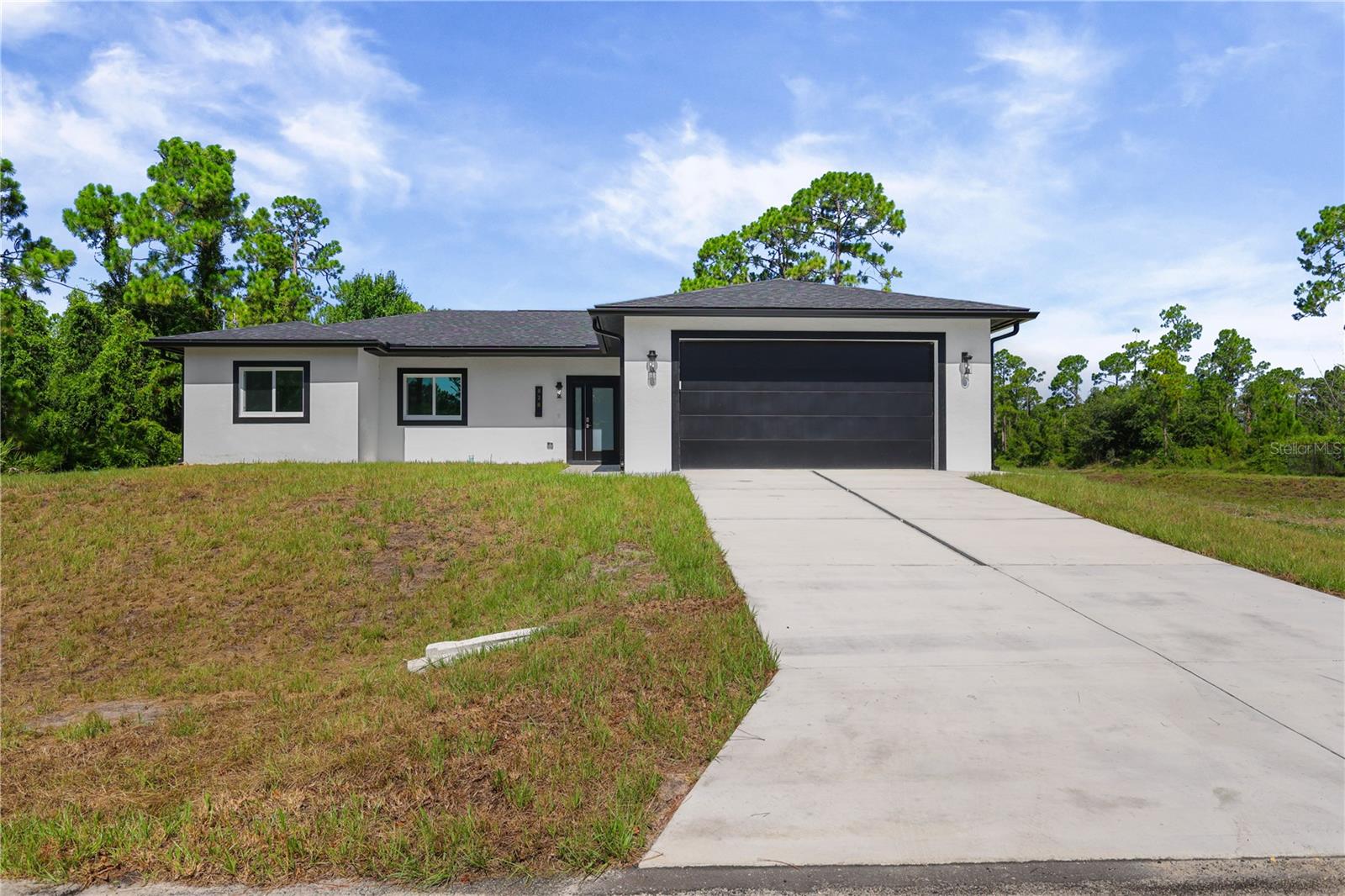 Welcome to this brand new 2026 built home offering 4 bedrooms and 3 baths (2 full, 1 half) across 1,632 sq ft of living space, set on a spacious .26 acre lot. Inside, the kitchen is a standout, featuring a large island, sleek white cabinetry, quartz style counters, and a full suite of stainless steel appliances including a gas range, dishwasher, disposal, and self cleaning oven. It opens seamlessly into the great room and dining area, all finished with tile flooring throughout for a clean, modern feel. The split bedroom layout offers privacy and flexibility, with a primary suite featuring a walk in closet and en suite bath, while the remaining bedrooms are thoughtfully separated, each with generous closet space. Additional features include an interior laundry room, an open, covered back porch overlooking the backyard, impact resistant doors and windows, and an attached 2 car garage. Built for comfortable, low maintenance living, and located in a no subdivision setting in Southeast Lehigh Acres, this move in ready new build offers a great opportunity for buyers seeking modern construction with room to make it your own.