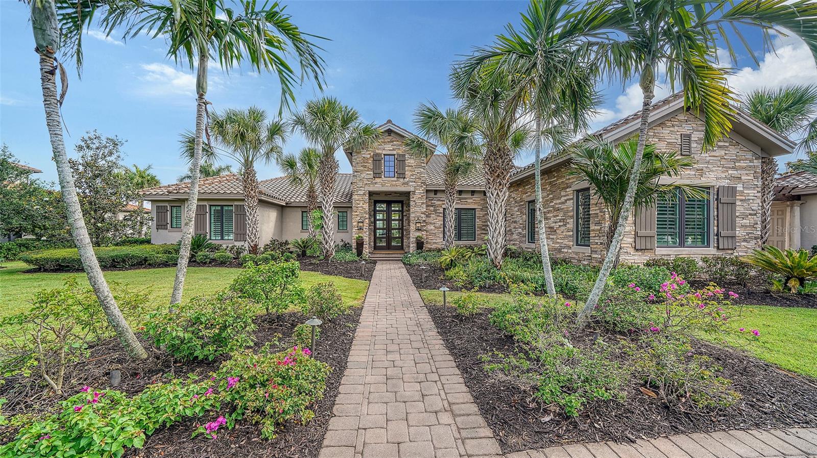 New price, now listed without the designer furniture package and with several home improvements made. A former Anchor Builders premier neighborhood model home, this exquisite residence will immediately make you envision your elevated life of luxury. The Lake Club is the most exclusive village in Lakewood Ranch, the nation's best selling all-ages master planned community. Peace and privacy abound, with a gorgeously landscaped linear park out the front door and a serene 160' lakefront setting in the backyard. At 5,249 square feet of living space, plus another 2,125 of covered outdoor space, the resort style pool, and the nearly 1-acre yard, this single-story home has all the room you need to live in comfort. This one of a kind residence was originally designed and furnished by Marc-Michaels Interior Design, a nationally renowned design firm. Roy Dupuis and his team at Anchor Builders gave every inch of this house exquisite attention to detail. You'll find 14' ceilings throughout the home, each with an architectural element such as crown molding, tongue and groove, or coffered design. The more you look around, the more you will fall in love with the details and beauty of this light and bright home. The kitchen is equipped with matching SubZero refrigerator and freezer that effortlessly blend into the ample cabinetry. Natural gas throughout fuels the Wolf oven and stove, grill, water heater, and two fireplaces. Guests will love gathering around the large kitchen island or mingling in the formal living room before sitting down at the oversized dining table. The screened outdoor patio is also the perfect place to gather, grill in the outdoor kitchen, or even just relax by the outdoor fireplace on your own with the gorgeous view of the lake. When you are ready for a swim, you will feel like you are on vacation with the pool perfectly nestled in the palm trees and with ample privacy from the neighbors. Each of the home's 4 bedrooms include an en-suite bathroom and walk in closet to make you and your loved ones feel right at home. A full pool bathroom and a powder room make the perfect options for guests. The master suite includes a sitting area flooded with natural light and room darkening Hunter Douglass remote-powered window treatments for those days you want to sleep in. Walk from the master bedroom into the bathroom past his and hers walk-in closets and you'll find the stand alone tub and split vanities with an extra counter space for the lady of the house to sit and do her makeup in the morning. Porto Cochere garage design gives you 3 spaces and complements the Tuscan inspired elevation.


This custom estate home is located in the heart of The Lake Club, with the amazing all-new Grande Clubhouse just a quick walk or golf cart ride away. Its new modern interiors include an enhanced lobby with new beverage bar, beautiful new furnishings in the concierge area and billiard room, spa, advanced audio/video technology in the board room, and an expanded fitness area. In addition to the regal 20,000 square foot Grande Clubhouse, the activity hub also has a tennis center and two pools for neighbors to enjoy. The Lake Club has programming to fit everyone's idea of fun- from card games and book clubs, to Easter Egg hunts and holiday brunches, you will find it all to share with your wonderful neighbors in this much sought after community. Book your private tour of this luxurious home today and come live The Lake Club lifestyle!