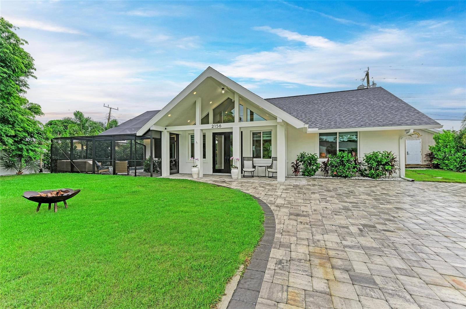 If you’re looking for a true “wow” factor, this stunning new-construction residence delivers. This custom-designed home combines luxury finishes with thoughtful functionality. Step inside to soaring 16-foot ceilings and dramatic exposed beams in the great room, creating an impressive sense of space. The chef’s kitchen is the centerpiece, featuring a striking brown agate back-lit island, granite countertops, modern cabinetry with pullouts and utensil organizers, an eight-burner professional range with bread and baking oven, custom vent hood, and upscale appliances—perfect for entertaining. Throughout the home, you’ll find large-format tile floors, custom window treatments, and the option to purchase designer furnishings. Offering 3 spacious bedrooms and 2.5 baths, this residence blends style and comfort seamlessly.
Outdoor living is just as impressive, with a brand-new modern pool and pool cage (completed August 2024), a Jacuzzi brand hot tub, and a private outdoor shower with hot and cold water. The property is professionally landscaped, freshly painted inside and out (August 2025), and boasts impact windows and doors, ensuring safety, efficiency, and some of the lowest homeowners insurance rates available. Additional highlights include a tankless gas water heater, gas and electric dryer connections, and no flood zone location. Situated on one of Sarasota’s highly coveted “Flower Streets,” this property offers rare flexibility: the City of Sarasota permits 7-night minimum rentals, and the home is not subject to Southgate deed restrictions. Just 1 mile south of Sarasota’s luxury waterfront downtown, and less than 3 miles to the world-famous Siesta Key Beach, the home is also walkable to Conner’s Steakhouse, Baker & Wife, shopping, dining, banks, and groceries—all tucked away on a quiet dead-end street.