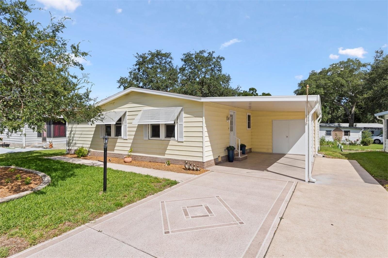 Turnkey and beautifully updated on the Historic Side of The Villages in beautiful Orange Blossom Gardens. This NO BOND 2-bedroom, 2-bath home offers drywalled walls throughout, a bonus Flex room that can be used as an office or den with a closet for storage. This home features a long list of quality upgrades. Enjoy a custom chef’s kitchen (2022) featuring KitchenAid appliances, custom cabinetry, retractable heavy-duty shelving, cooktop stove, and an unused convection oven. Solar tubes provide abundant natural light throughout the home. Updates include composition roof (2020), HVAC (2019), both bathrooms remodeled (2024), new windows, double-pane sliding glass doors, water purification system, irrigation system, gutters/downspouts (2022), and newer washer/dryer sits inside a large double door shed with ample room for storage and a Golf Cart parking area. Plenty of room for parking on the extended and Stamp painted driveway. Relax on the screened deck with cooling shades while enjoying GOLF COURSE VIEWS! Home is being sold TURNKEY with all new furnishings included—move-in ready and waiting for its next owner. Grab this little slice of Paradise before it's gone!!
