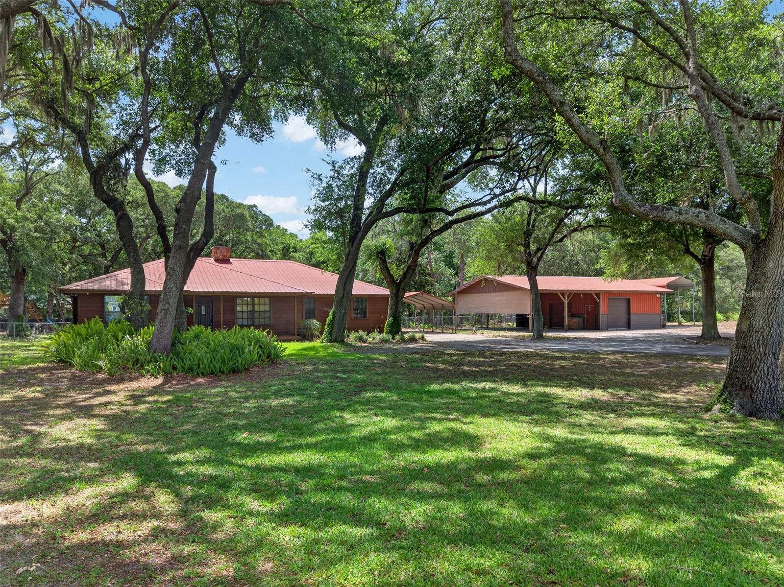 Private Lakefront Pool Home on Over 1 Acre. Nicely Updated with oversized workshop & space for all your toys. Rare opportunity to own a beautifully updated pool home in a peaceful setting—just minutes from downtown. Situated on over an acre of fully fenced backyard, this property offers privacy, functionality, and stunning views of a private lake right from your front porch, framed by mature oak trees. The home features beautifully updated interior, including a modern cabin feel kitchen and renovated bathrooms, along with a durable metal roof for long-term peace of mind. Step outside to enjoy the screened-in pool with a spacious deck—perfect for entertaining or relaxing. The pool has been recently resurfaced, and major systems like the drain field were replaced just two years ago. This property truly stands out with its detached garage, oversized carport, and additional covered space ideal for an RV, boat, or work equipment. Whether you run a construction business, need a workshop, or just have a lot of toys, this setup gives you the flexibility you won’t find elsewhere. Enjoy direct access to the private lake with your own floating dock, plus a custom-built treehouse and plenty of open space to enjoy the outdoors. Quiet, private, and move-in ready—this is the kind of property that rarely hits the market. FHA Offers accepted after June 7, 2026.