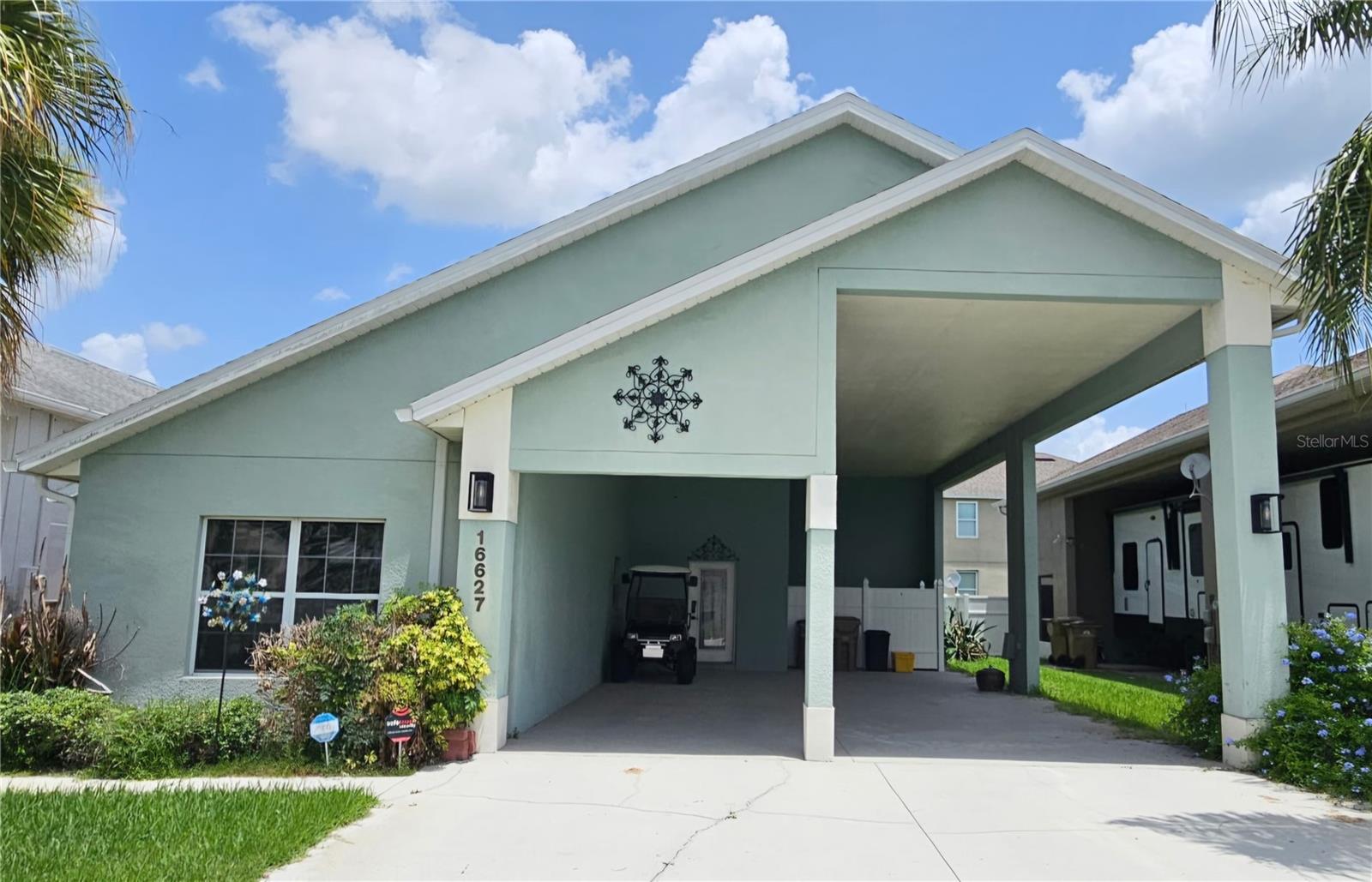 Short Sale. Come see this well-maintained single-story RV PORT home nestled inside the desirable community of Citrus Highlands, located near the world's most magical theme parks and attractions! From the moment you arrive, soaring gable rooflines, a soft sage stucco exterior, and mature palm landscaping set a relaxed, coastal-Florida tone. The oversized 50 ft covered double carport is a standout feature — FULL RV Hook-ups including water, sewer, TV plus 20, 30, & 50 AMP Electrical service. There’s additional covered parking for a car &/or golf cart. Step inside to find vaulted ceilings throughout, giving every room an airy, open feel. The main living areas flow seamlessly across luxury vinyl plank flooring, creating a bright, low-maintenance foundation for the whole home. The kitchen is well-equipped with crisp white cabinetry, dark speckled countertops, a breakfast bar with pendant lighting, and a full suite of appliances, making it ideal for everyday cooking or entertaining guests. Adjacent to the kitchen is a huge laundry room with pull-down stairs and storage above which includes a new washer and dryer. The primary bedroom offers a peaceful retreat with a spacious walk-in closet containing built-in shelving, and a private en-suite bathroom featuring a dual-sink vanity with a dark speckled countertop, a separate walk-in shower with tiled surround and a grab-bar for added convenience, plus a private water closet and generous linen storage. The additional bedroom is equally inviting, with neutral carpet, ceiling fans, tall ceilings, and large windows that fill the room with natural light. A second full bathroom offers a matching dual-sink vanity and a glass-enclosed shower, making mornings easy for family or guests. Recent updates include: a brand-new AC system, roof replacement in 2023, and a new hot water heater in 2019. These major upgrades offer peace of mind for years to come. Out back, a covered lanai area extends the living space outdoors, perfect for morning coffee or evening relaxation in the Florida sunshine. A Hot Tub outlet is already pre-wired for your convenience & there's additional gated storage for your personal items. Located in a friendly Clermont neighborhood close to shopping, dining, and easy access to major roadways, this home combines comfort, functionality, and recent big-ticket updates. Whether you're searching for a full-time residence or a seasonal Florida getaway, this property offers space, storage, and updated systems to make life easy. Don't miss this incredible opportunity — schedule a showing today!