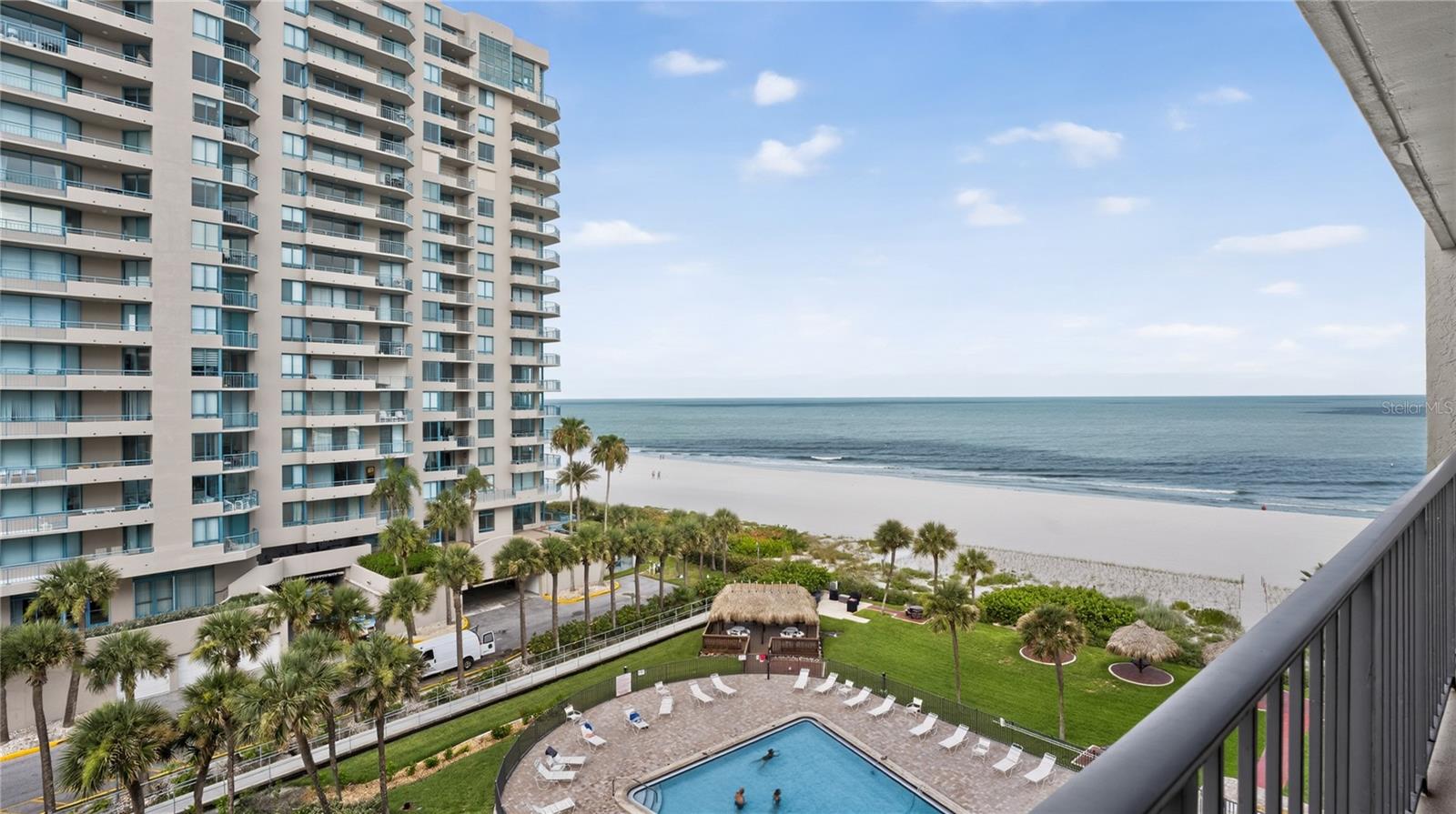 ***PLEASE CLICK ON VIRTUAL TOUR BUTTON***Wake up to panoramic Gulf views and sun-filled days in this beautifully updated, turn key furnished, south-facing beachfront condominium! As you enter, soft neutral tones, wide-plank luxury vinyl flooring, crown molding, and contemporary finishes complement the breathtaking beach backdrop visible throughout the main living spaces. Love the furnishings?  This condo is being sold with all furnishings and housewares included! The centerpieces of the entry way and living area are stunning custom-built architectural feature walls with illuminated display niches welcoming you in creating a sophisticated coastal ambiance while providing the perfect showcase for artwork and treasured décor. Rich espresso cabinetry, sleek stainless-steel appliances and an oversized quartz island with seating adorn the open kitchen, a perfect place to enjoy refreshments after a day at the beach. The spacious living area seamlessly connects to a private balcony where you can relax with morning coffee or take in spectacular sunsets over the water with a night time cocktail. Expansive windows and sliding glass doors flood the interior with natural light and frame unobstructed shoreline views, effortlessly blending indoor and outdoor living. The balcony serves as an extension of the home, offering a front-row seat to the sparkling Gulf waters and soothing sounds of the surf. The primary suite also offers balcony access along with an en-suite bathroom featuring custom closets, an oversized shower with pebble-stone flooring creating a luxurious resort-style experience. With a split bedroom floor plan, the guest and primary bedrooms are located on opposite sides of the unit providing ultimate privacy. The guest bedroom features intercoastal views from its large triple window and built in closets. Step from the lobby to the sand in minutes - yet the private, uncrowded coastal setting makes it feel worlds away from the bustle of nearby Clearwater Beach. Beyond your door, amenities rival the finest for resort living year round: a heated waterfront pool, grilling station, poolside tiki bar, and beachfront tiki huts create the ultimate backdrop for leisure. There's also a clubhouse with full kitchen, lounge area and bathrooms on the 2nd floor lobby level. Assigned carport parking (newly resurfaced parking lot), a private storage unit, and a pet-friendly policy add everyday convenience. With a guard gate, keyed lobby, Milestone & SIRS reports complete, flood insurance provided by the HOA, and a new building generator, peace of mind is built right in. Monthly fee also include water, sewer, trash, cable, and internet. Perfectly positioned near Sand Key Beach State Park (nature trails and dog park), Bay Park (pickleball/tennis, playground), Shops On Sand Key (dining/retail) and Clearwater Beach’s vibrant dining, boutique shopping, and marine activities. Every detail of this residence reflects a refined coastal aesthetic—bright, airy, and thoughtfully curated for everyday comfort. Whether you're seeking a full-time beachfront residence or a luxurious coastal getaway, this exceptional condominium offers the perfect balance of elegant design and an unbeatable waterfront setting.