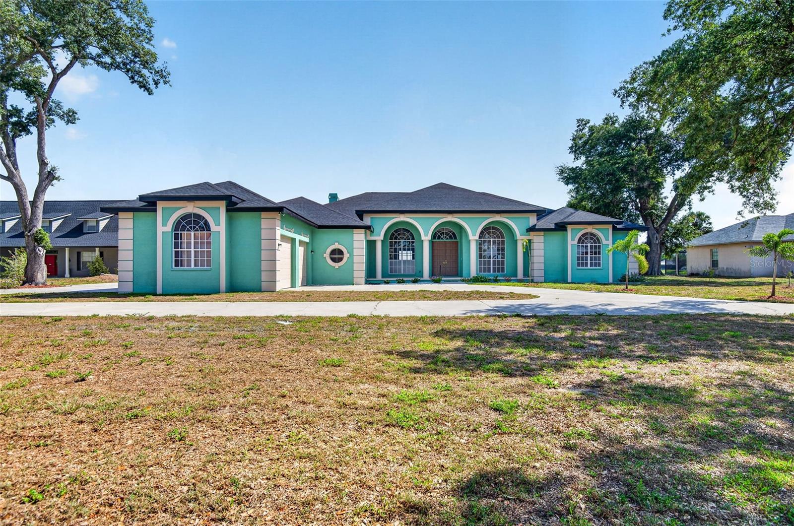 One or more photo(s) has been virtually staged. THIS IS THE KIND OF NEIGHBORHOOD PEOPLE ARE ALWAYS LOOKING FOR — a small custom community with NO HOA, nice lots, and homes full of character instead of cookie-cutter designs  ~  This Homeowner built this house and has lived there the entire time!  ~  Situated on a beautiful POND LOT, this SPACIOUS 3,684 SF CUSTOM BUILT -  this home offers the opportunity to create the dream home you’ve always wanted  ~  Inside, you’ll love the IMPRESSIVE 12’ CEILINGS in the main living areas and 10’ ceilings in the bedrooms, giving the entire home an open, airy feel  ~  The layout features a large formal Living Room and Dining Room, plus a comfortable Family Room with a fireplace that’s perfect for gathering and relaxing  ~  The spacious Kitchen offers abundant cabinet space, a breakfast bar, and plenty of room for entertaining or everyday living  ~  Large sliding glass doors span across both the Formal Living Room and the Family Room, filling the home with NATURAL LIGHT while providing BEAUTIFUL, CONTINUOUS VIEWS OF THE POND from the main living areas ~ The home features THREE QUADRUPLE SLIDING GLASS DOORS THAT POCKET COMPLETELY AWAY for an incredible open-air feel and seamless indoor/outdoor living, plus TWO ADDITIONAL TRIPLE SLIDING GLASS DOORS that bring in even more light and showcase the peaceful water views throughout the home  ~   With 4 large bedrooms and 4.5 bathrooms, everyone has space to spread out  ~  EVERY BEDROOM HAS ITS OWN ADJOINING BATHROOM, and three of the bedrooms feature walk-in closets  ~  All of the rooms are generously sized, offering comfort and flexibility for family and guests alike ~ AND WAIT UNTIL YOU SEE THE PRIMARY SUITE!  ~  Step outside to enjoy the HUGE SCREENED LANAI — an incredible outdoor living space designed for relaxing, entertaining, and everyday enjoyment ~ The main covered and screened area stretches approximately 50 x 20 along the back of the home from the main living areas past the Primary Suite — PERFECT FOR PARTIES, family gatherings, or simply enjoying peaceful pond views  ~  Additional screened seating areas off the Family Room and guest bedroom create ideal spaces for morning coffee, evening wine, or giving guests their own private outdoor retreat  ~  Under roof and enclosed with a birdcage, this expansive lanai offers endless possibilities  ~  There is still PLENTY OF ROOM FOR A POOL, a protected GARDEN SPACE, or simply a safe place for pets to roam freely outdoors  ~  The backyard overlooks a peaceful pond where you can build your own dock and launch a KAYAK right from home  ~  The exterior offers even more to love, including a welcoming front porch, circular driveway, and an OVERSIZED 4-CAR GARAGE WITH HIGH CEILINGS  ~  TWO OF THE GARAGE BAYS FEATURE DOORS ON BOTH ENDS for easy pull-through access — PERFECT FOR BOATS, TRAILERS, TOYS, extra parking, or convenience  ~  The garage setup is also IDEAL FOR A LARGE WORKSHOP, hobbies, storage, or anyone needing serious workspace  ~  While the home is ready for updating, that’s exactly what makes it such an exciting opportunity — the chance to personalize every detail and make it perfectly yours in a truly one-of-a-kind neighborhood  ~  Come see if this is YOUR NEW HOME!  ~  PRICED TO SELL!