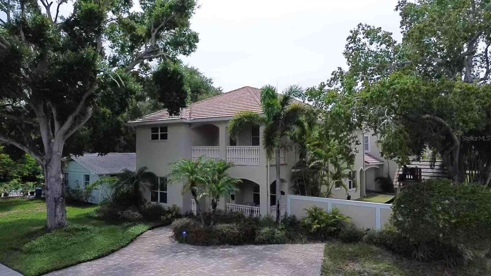 South Tampa Corner-Lot Retreat. This beautifully appointed home offers 4 bedrooms and 3.5 bathrooms in the main house, plus a standalone poolside full bath with shower, and a bonus in-law suite with full bath above the oversized 3-car garage and workshop.  Lots of exterior off street parking spots large enough to accommodate an RV.  A stucco privacy wall and lush tropical landscaping wrap the backyard in seclusion, centered around a freeform saltwater pool with waterfall. Covered lanais offer space for both dining and cozy evenings by the fireplace, with a separate covered area with outdoor kitchen. Kids and pets will love the turf side yard, complete with a climate-controlled playhouse, swing set, custom sand box, and basketball goal. Inside, wood floors, crown molding, and built-in bookcases. Formal living and dining rooms anchor the front of the house, while a flexible den/playroom/office sits just off the family room. The chef’s kitchen opens to the family room and features a large Sub-Zero refrigerator and freezer, coffee/beverage bar, along with a pantry and under-stair storage. Upstairs, the spacious primary suite includes dual walk-in closets, a spa-inspired bath with therapeutic shower, double vanity, and private water closet. Bedrooms 2 and 3 share a Jack-and-Jill bath, and bedroom 4 (currently office with closet framing pending) has its own en-suite. The laundry room is conveniently located on this level as well. A whole-home Generac generator adds extra peace of mind, and the home’s FEMA Flood Zone X designation means no flood insurance is required. Built with solid concrete block construction on both levels and topped with a concrete tile roof, this home offers exceptional structural integrity. Attic and wall insulation are top-notch as well, thanks to a builder-owner who spared no detail in the original construction. Walkable to Plant High School, dining, and shopping— South Tampa living at its finest.