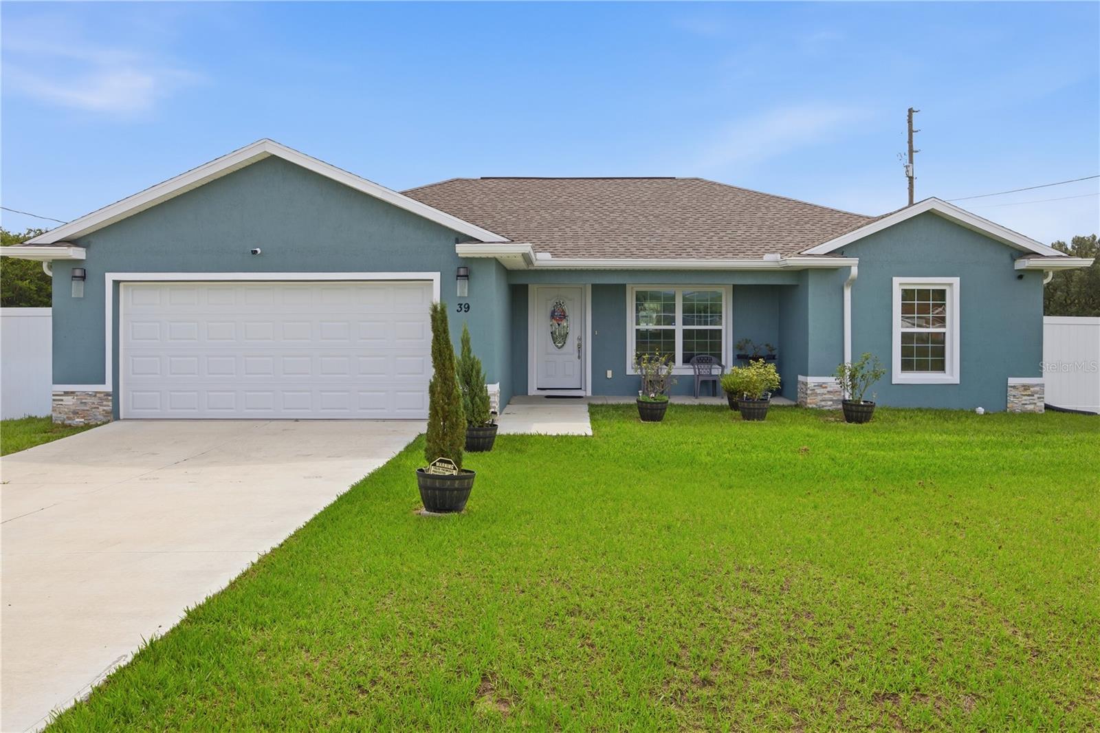 Welcome home to this beautifully maintained 3-bedroom, 2-bathroom home situated on an oversized corner lot with modern stone accents and a fully vinyl privacy-fenced backyard. Ideally located near golf courses, shopping, dining, entertainment, Lake Weir, and the renowned Santos Trailhead, you'll enjoy easy access to some of the very best outdoor recreation and conveniences in Ocala.
Step through the covered front entry and discover a bright, open, split-bedroom floor plan designed for everyday living. Stunning custom porcelain tile flooring gives a luxurious feel throughout the home. The designated dining area flows to the gourmet-inspired kitchen, featuring granite countertops, stainless steel appliances, a deep farmhouse sink, abundant cabinetry, and a breakfast bar that's perfect for morning coffee or casual meals. The private primary suite offers a relaxing retreat with a walk-in closet, granite-topped vanity, and a spacious walk-in shower. Two additional bedrooms provide flexibility for family, guests, or a home office. Step out back to the covered lanai which brings your living space outdoors and overlooks the large backyard—an ideal setting for weekend barbecues, entertaining friends and family, or simply unwinding while enjoying Florida's beautiful sunsets. Enjoy Florida living at its finest.