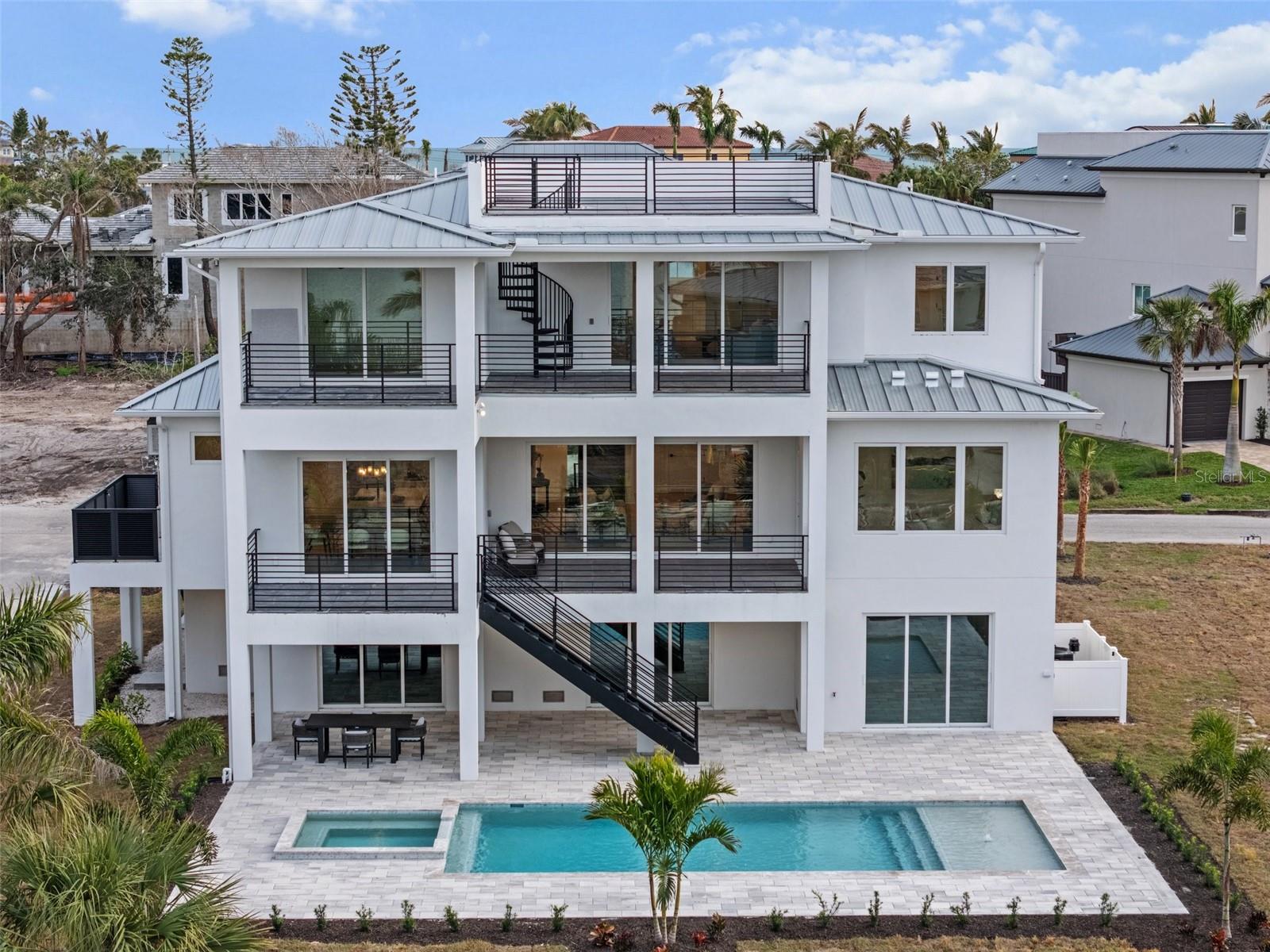Completed New Construction – Best-Priced Luxury New Construction on Longboat Key!

Gulf & Bay Views | Private Tropical Oasis | Three Outdoor Living Areas

Move in today and experience the best value in luxury new construction on Longboat Key. Built by Floridian Crafted Homes, this completed coastal contemporary residence combines exceptional craftsmanship, hurricane-resilient construction, and an unbeatable location just steps from the beach.

Elevated approximately 13 feet above sea level, this stunning home offers 4,176 square feet of thoughtfully designed living space with 5 bedrooms, 5 full bathrooms, and 2 half bathrooms. An elevator shaft has already been framed and is ready for elevator installation.

Designed for effortless indoor-outdoor living, the home features three expansive outdoor entertaining spaces, including two private balconies and an incredible rooftop terrace showcasing panoramic Gulf and Bay views with unforgettable sunset vistas.
Inside, the spacious open-concept great room seamlessly connects to the designer gourmet kitchen, creating the perfect setting for entertaining family and friends. A second-floor club room provides additional flexible living space ideal for a media room, game room, or private retreat.

Step outside to your own private tropical oasis, where lush landscaping surrounds a sparkling resort-style pool and spa, creating a secluded backyard retreat rarely found in new construction on Longboat Key. The oversized 5+ car garage provides abundant space for vehicles, golf carts, water toys, and beach equipment.

Perfectly situated just a short walk to the Gulf beaches and the exciting new retail and dining destination anticipated to open nearby, this home also offers access to a community marina with available boat slips, making it an exceptional choice for boating enthusiasts.

With completed construction, premium finishes, breathtaking Gulf and Bay views, a private tropical backyard, and one of the most competitive prices for luxury new construction on Longboat Key, this is an extraordinary opportunity to own a truly exceptional island home.