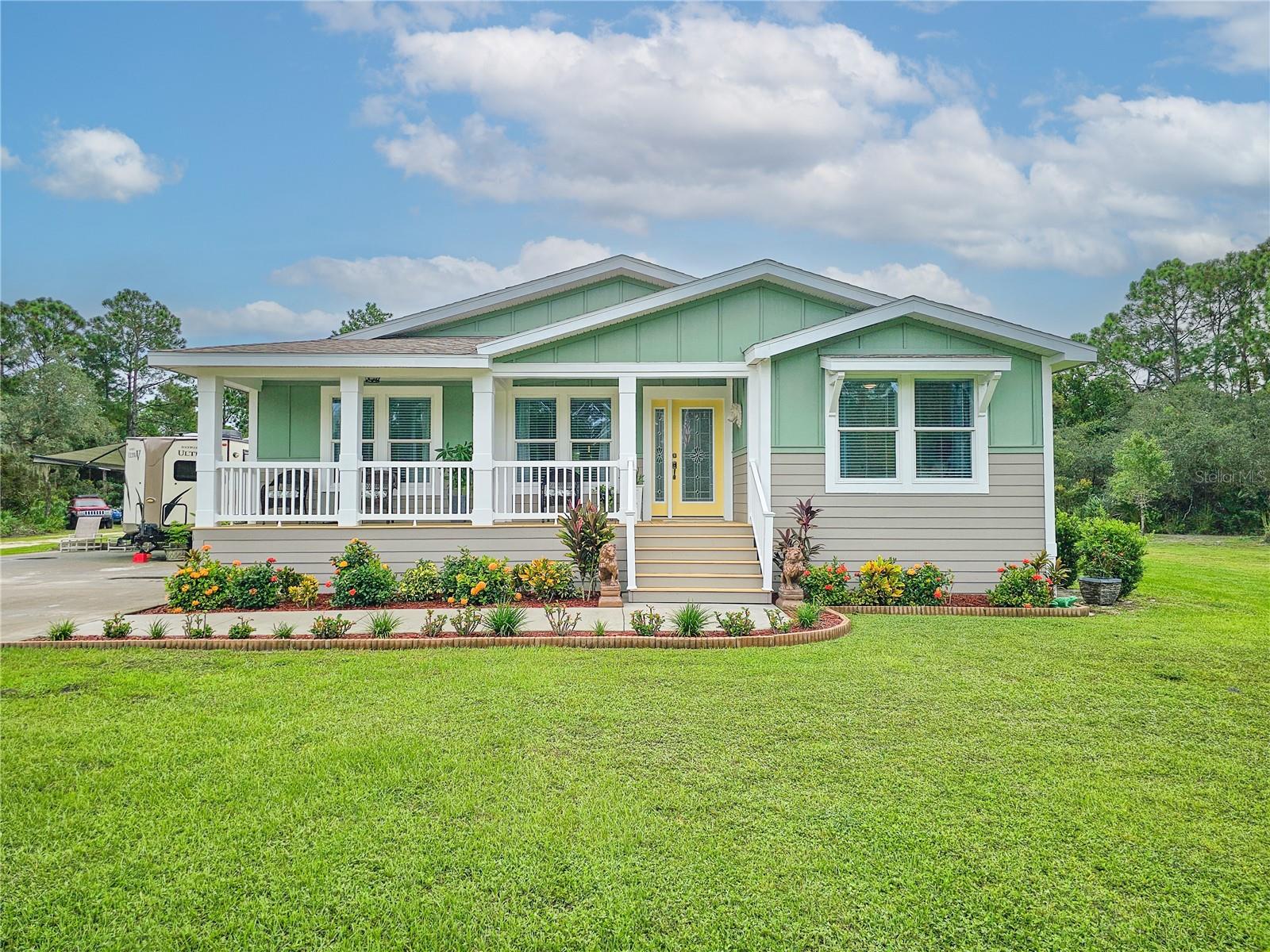 Situated on nearly 3 beautifully landscaped acres, this well maintained 2019 modular home offers the perfect blend of privacy, space, and modern upgrades. With over 2,200 sq ft of living space, this 3 bedroom, 2 bath home is being sold fully furnished with high-end, tasteful furniture, making it truly move in ready! Inside, the open concept layout is highlighted by 9-foot cathedral ceilings and luxury vinyl plank flooring throughout the main living areas. The kitchen features granite countertops, soft-close cabinetry, stainless steel appliances, and an oversized 10-foot island with seating for six. The primary suite includes a double vanity, oversized garden tub, spacious walk-in closet, and private access to the rear covered porch. Both front and back porches provide comfortable outdoor living spaces, with access from the primary bedroom and formal dining room. Additional features include hardy board siding, paved driveway with electric security gate, full water filtration and softener system, indoor laundry room, and two outbuildings- one housing the filtration system and the other a 10x20 workshop. 
***The previous above-ground pool has been removed, but the property offers ample space to add a future pool.*** The mostly cleared, landscaped acreage provides room for boats, RVs, trailers, or future expansion while maintaining a private, peaceful setting. Conveniently located just a short drive to the beach, Intracoastal Waterway, shopping, and the Space Coast!