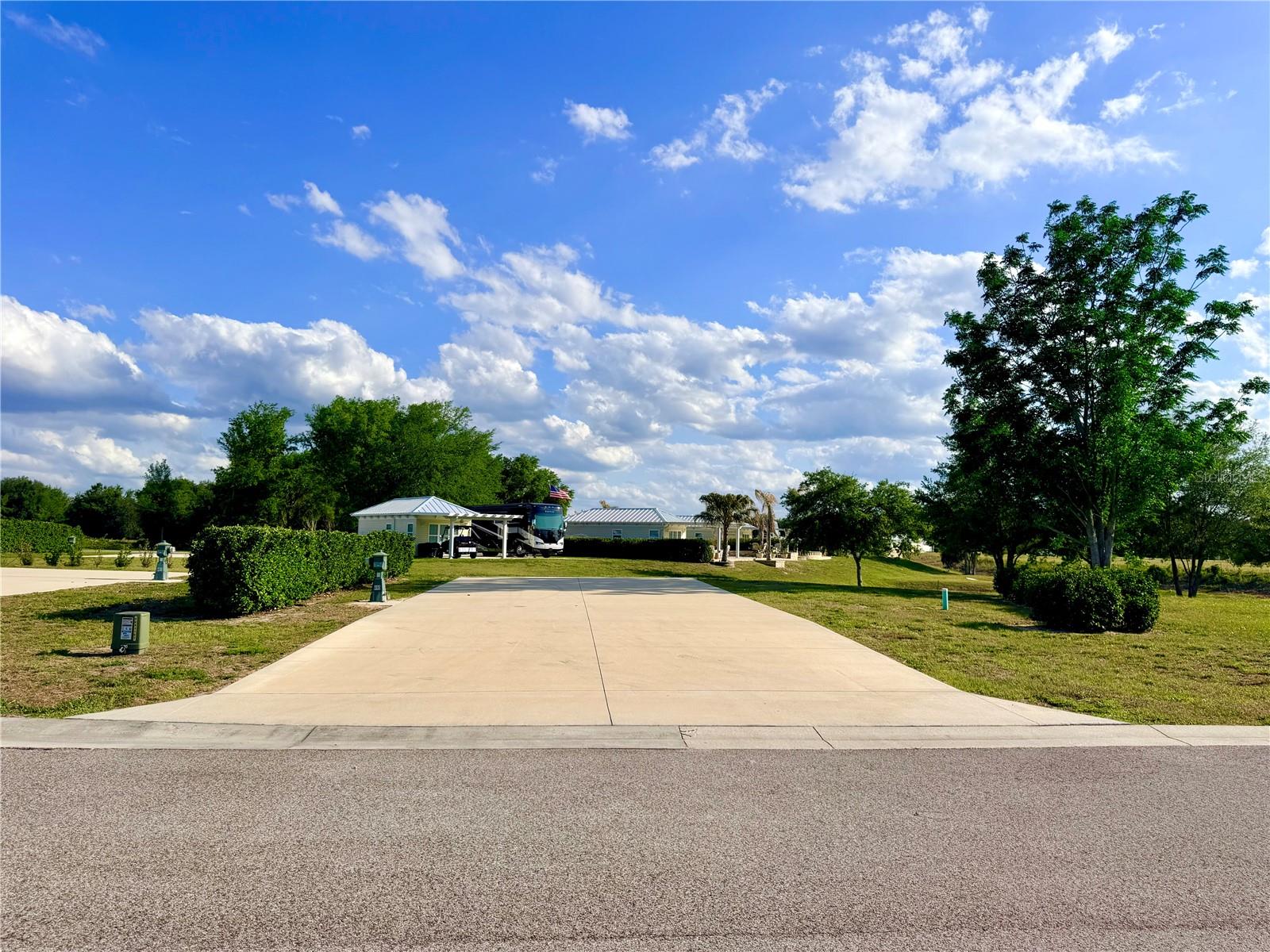 Secure your place in Florida Grande Motor Coach Resort with this spacious 5,950 sq ft pull-in property featuring a 26x76 concrete motorhome pad and room to build a future Grande Suite when the time is right. This is an excellent opportunity for buyers planning ahead who want to enjoy the resort now while preserving flexibility for future improvements. Florida Grande is a sought-after Class A and Super C resort offering deeded ownership and outstanding amenities including a 20,000 sq ft clubhouse, fitness room, library, game room, craft room, dog park, and miles of scenic walking trails. The resort comes alive during the winter season with regularly scheduled activities, social gatherings, and special events that create a true sense of community where neighbors become friends. Owners may rent their property when not occupying, making this an attractive option for seasonal or future retirement planning. Conveniently located in Central Florida near Ocala, Orlando, Tampa, and The Villages, this peaceful location offers endless opportunities for day trips and adventures that family and friends will love to experience.