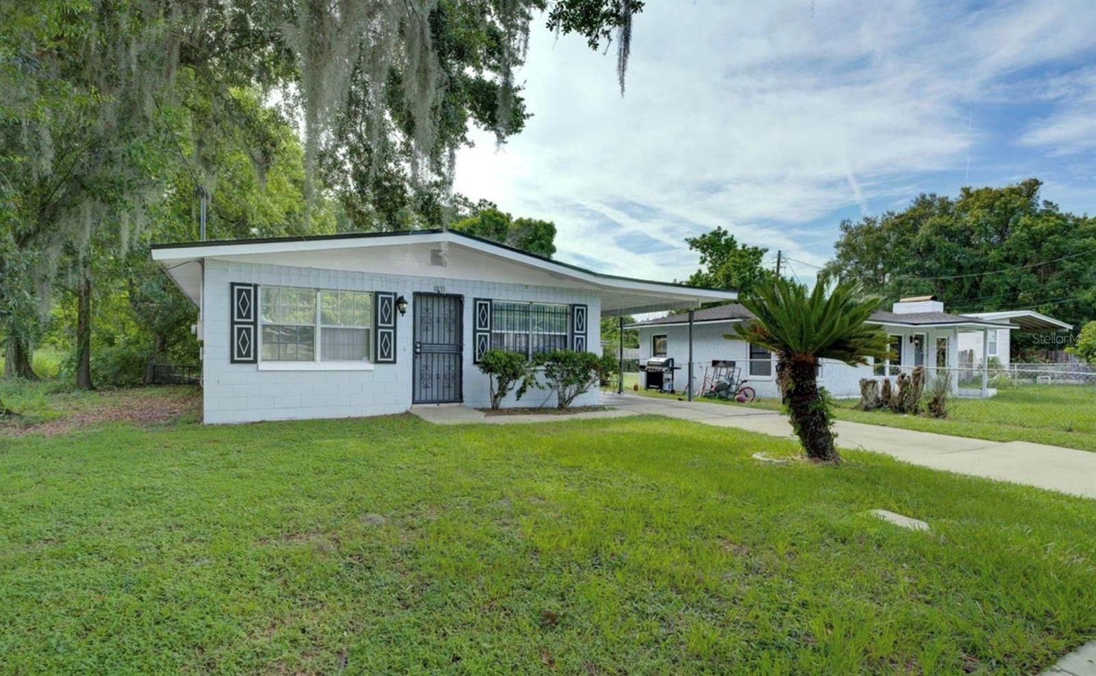 This is a great 3 bedroom, 1.5 bathroom home. The 3 bedrooms share an updated guest bathroom with a step-in shower. The primary bedroom has its own 1/2 bathroom. There is a 1-car carport, and a huge fenced-in backyard. The 1-car carport hosts a storage room where there is a washer/dryer hookup and the newer hot water heater. The home comes completely FURNISHED with a queen sized bed, desk, and chair included in each room. The living room is separated, and is currently being used as a large 4th bedroom, and it has its own mini-split AC unit. This can be used as a living room, or kept as a bedroom. The hot water heater is 4 years old. Roof is new in 2023. Inside AC unit is 2021. This is a very quiet dead-end street, close to I-4. Makes for a fantastic and affordable rental, or first time home!