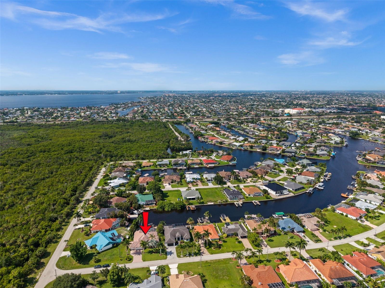 RESORT-STYLE TURNKEY GULF ACCESS HOME IN FOUR MILE COVE WITH SOUTHERN EXPOSURE, 130-FOOT CANAL VIEWS, AND QUICK ACCESS TO OPEN WATER! Welcome to 2106 SE 20th Ln, a beautifully updated 3-bedroom + office, 3-bath waterfront home offering 2,377 sq ft of living space, Southern rear exposure, and AMAZING VIEWS across a 130-foot-wide canal. Sold TURNKEY furnished with newer furniture, this home feels like resort-style living from the moment you arrive, with mature landscaping, decorative curbing, a paver driveway, 3-car garage, screened double-door entry, and a dramatic arched transom window opening to the foyer. Inside, the open main living area features SOARING VAULTED CEILINGS, lots of natural light, new flooring, remote-controlled electric blinds, an electric fireplace, and indoor/outdoor Sonos sound. The kitchen offers granite countertops, abundant cabinetry, stainless steel appliances, breakfast bar seating, WALK IN PANTRY and a built-in desk area. The spacious primary suite overlooks the water and includes a sitting area, tray ceiling, lanai access, walk-in closet, and large bath with dual sinks, makeup vanity, soaking tub, and separate shower. The SOUTHERN EXPOSURE backyard delivers all-day sun on the screened lanai, saltwater pool, spa, waterfall, and swim-up bar. Boaters will love the composite dock, 13,000 LB BOAT LIFT with Gem remote, and QUICK GULF ACCESS with open water in approximately 20 minutes. Additional features include electric roll-down hurricane shutters, 2022 AC, 2024 washer and dryer, laundry room with sink and cabinets, and pool storage under air. THIS HOME HAS NEVER FLOODED IN ANY STORM. Located near shopping, dining, parks, and everything SE Cape Coral has to offer!