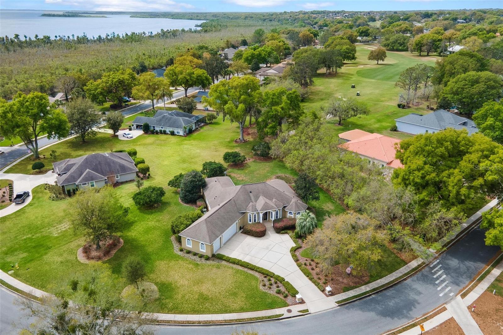 GOLF FRONTAGE STUNNING HOME...enjoy views of the 10th green from the front and rear views of the 11th Tee. Spectacular location in a desirable neighborhood with 24/7 guard gated security and sidewalks for your walking pleasure! This custom home boasts over 3,000 square feet of living space plus room for all your cars and golfcart in a 3-car garage! Your guests will be impressed with the grand entrance to the foyer opening into the Great Room with gas fireplace, separate Formal Dining area and separate Den/Office! The Kitchen with a large dinette area is fit for a Chef with the oversized Island that's great for food prep or serving...Refrigerator, Smooth Top Range & Microwave approximately 3 years old! Gathering with friends is a delight in the Family Room with an additional Gas Fireplace and wall of glass sliding doors to backyard, bringing a feeling of sitting outside indoors. The Primary Suite features a sitting area, doors to lanai & custom stain glass. Plus, "Spa like" Bath with soaking tub, walk thru 2 headed shower and dual vanities with travertine countertops!! Split bedroom design gives privacy to bedrooms 2 & 3 that share the second bath with raised dual vanity and granite countertops. You will be captivated by the "one of a kind" remodeled 3rd guest bath that features a rare onyx flooring, shower wall and custom vanity! Additional upgrades include crown molding, high volume ceilings that range 10, 12 to 14 feet, water filtration/ softener, two HVAC replaced in 2018, Hot Water Heater replaced 2023, Custom Valances and more...Transferable Termite Bond!! Buyer can choose...Seller will commit to a NEW ROOF prior to closing or adjust to lower price!! Clubhouse membership is optional!! For additional fees you can join and have use of the Pool, Fitness, Marina with Chain of Lakes Access, Tennis, Pickleball, activities and more...