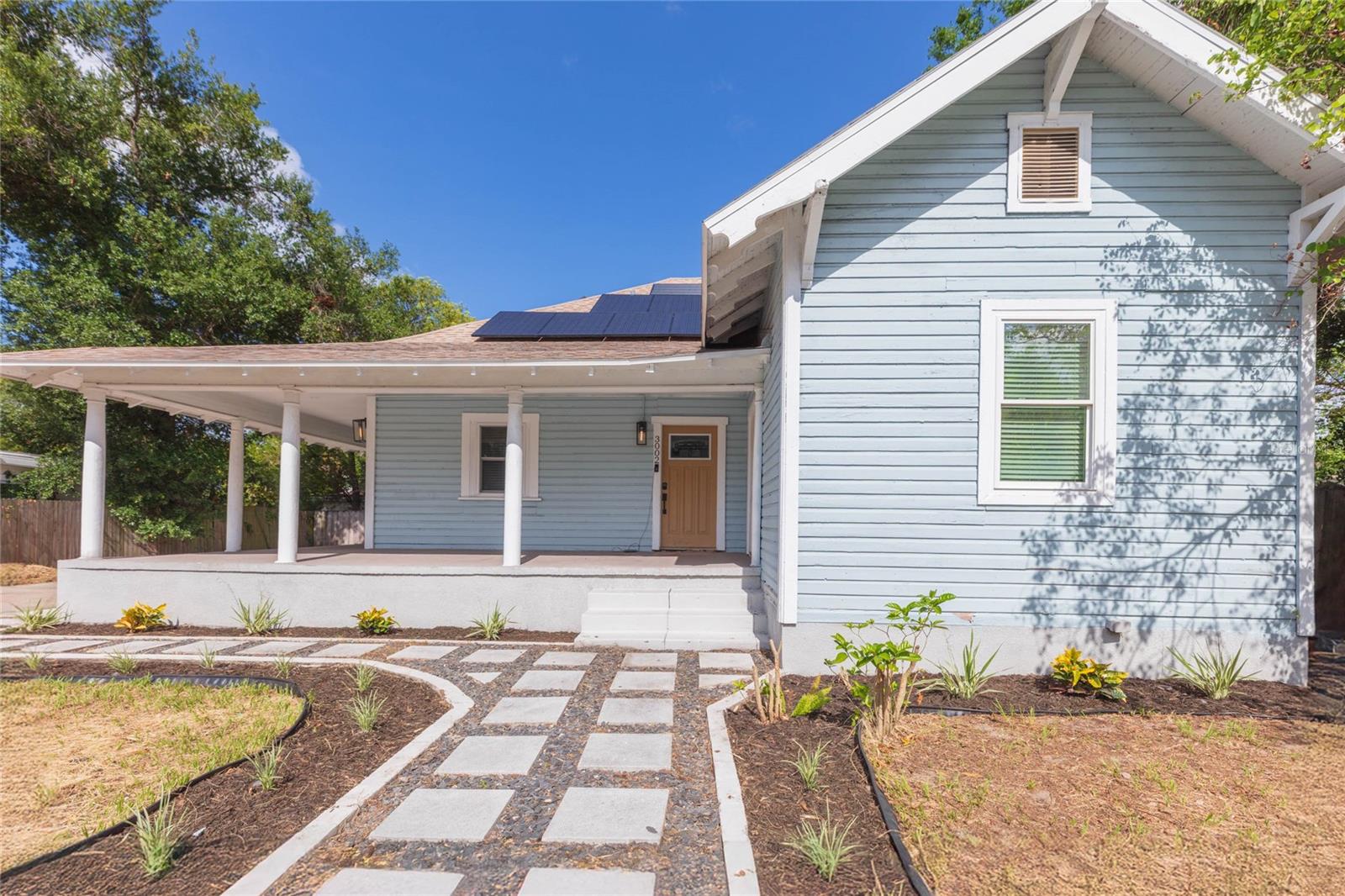 This charming 4 bedroom, 2 bath 1920s bungalow is the perfect blend of historic charm and modern convenience! The inviting wrap-around front porch, classic picket fence and updated landscaping creates instant curb appeal. Inside, you will find beautiful wood flooring installed in 2016, a split-bedroom floor plan for added privacy, and an updated kitchen in 2016 with granite countertops, mosaic tile backsplash, stainless steel appliances, tile flooring and a breakfast nook. The primary bedroom has an ensuite bathroom and the secondary bedrooms share the remaining full bath. Bedroom 4 has separate exterior access from the front porch which is ideal for guests or multi-generational living. Both bathrooms have been tastefully remodeled in 2020. The expansive fully fenced backyard has a spacious deck and 2 custom solid wood sheds with fiber cement siding, providing plenty of room for entertaining, storage, or hobbies. Bring your cars, RVS and more as the parking pad and driveway can accommodate all parking needs. Additional updates include FULLY PAID OFF SOLAR PANELS (2020), exterior paint (2020), interior doors (2020), roof (2016), AC (2016), updated electrical/panel (2016), PVC plumbing for main line and entire house (2016). Sought after Tampa location, close to downtown, Ybor, Seminole Heights and all the greater Tampa area has to offer. Enjoy long term savings with NO flood insurance needed, no HOA or CDD, fully paid off solar panels as well as a well pump with water filtration system resulting in no monthly water bill!