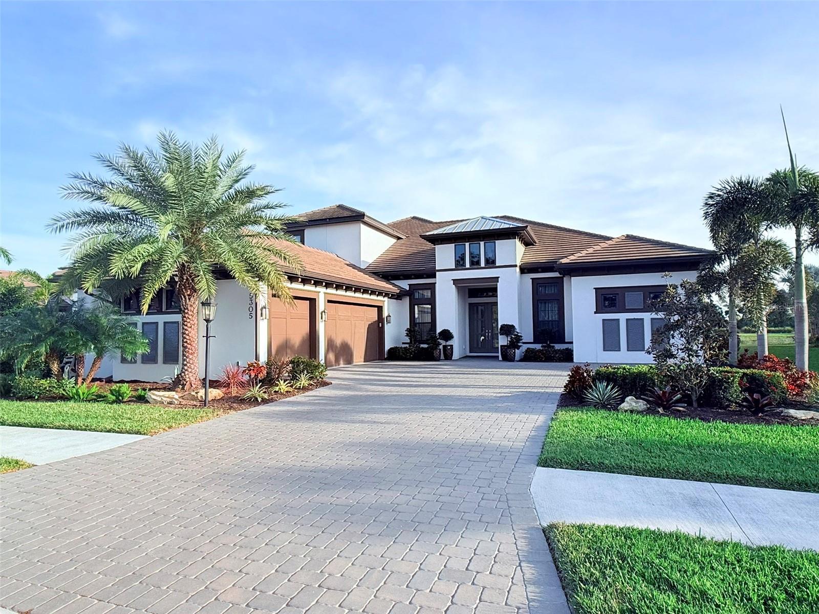 Welcome to 5305 Brookgrove Drive- Legacy Estates. This stunning, contemporary Beacon model home is perfectly positioned on one of the best lots in Legacy Estates, offering breathtaking views of a tranquil pond and serene preserve from the back, while the front overlooks a beautiful dog park—a rare combination of beauty and privacy. Step inside to discover a meticulously upgraded residence featuring 12-foot ceilings, custom tile and marble work throughout, elegant hardwood floors, and over 35 contemporary light fixtures that enhance the home’s ambiance. The gourmet kitchen is a chef’s dream, equipped with upgraded Monogram appliances, quartzite marble countertops, and premium cabinetry. The spacious living area is anchored by a striking 100-inch luxury fireplace with a designer tile surround and custom shelving, while built-in closets and upscale custom window treatments add both style and function. The expansive 2,500 sq. ft. lanai is a true showstopper designed for year-round resort-style living. Featuring a large heated salt pool and spa with elegant water features and a lounge area, travertine tile, an outdoor kitchen with a built-in grill, fridge, and bar, this space is perfect for entertaining or simply unwinding while enjoying the picturesque views. Hurricane-impact windows, four-zone heating, and custom landscaping complete the home’s high-end features. As part of the sought-after Esplanade on Palmer Ranch community, residents enjoy a world-class amenities center, a resort-style heated pool, splash pad, Bahama Bar restaurant, pickleball and tennis courts, and a fully equipped gym. And with award-winning Gulf Coast beaches just 15 minutes away, this home truly offers the best of luxury and lifestyle.