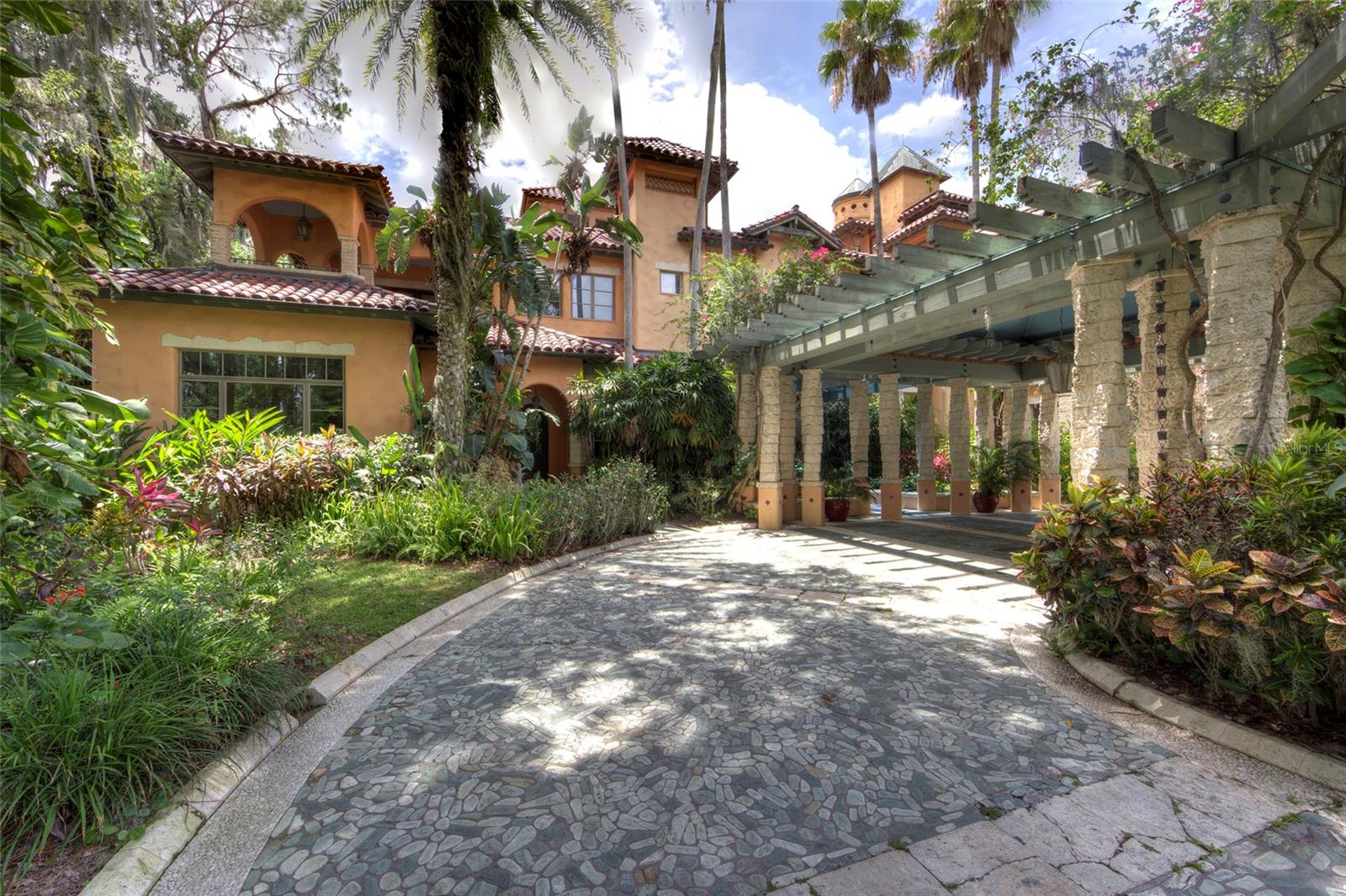 Entrelagos is a rare waterfront estate on a private peninsula between Lake Sheen and Lake Tibet, offering unmatched privacy and breathtaking views. Spanning 2.44 acres across two lots, the property includes a vacant buffer lot, ensuring seclusion within a gated community with 24-hour security.
?
?This three-story mansion on the prestigious Butler Chain of Lakes is designed for grand living and entertaining. It features six bedrooms, seven full baths, and two half baths, plus an office that can serve as an additional bedroom. The home boasts spacious living areas, a library with lake views, a game room, and a movie theater with custom-carved entry doors. A large chef’s kitchen with a butler’s pantry provides ample storage.
?
?The master suite offers stunning lake and garden views, a mini-kitchen, a Jacuzzi, and built-in lighted closets. The third-floor gym includes a full bath and opens to a 2,000-square-foot deck, perfect for entertaining and enjoying Disney fireworks. An elevator serves all three levels.
?
?Outside, the resort-style tri-level pool features waterfalls, a cabana bar, a summer kitchen, a spa, and a steam room. A three-bedroom guest house, staff quarters above a five-car garage, and a private two-slip covered boat dock add to the estate’s appeal.
?
?Prime location just minutes from Disney, Orlando’s top attractions, premier golf courses, and the airport, with direct access to world-class boating and fishing on the Butler Chain of Lakes. A rare opportunity to own a private waterfront retreat in the heart of Central Florida.