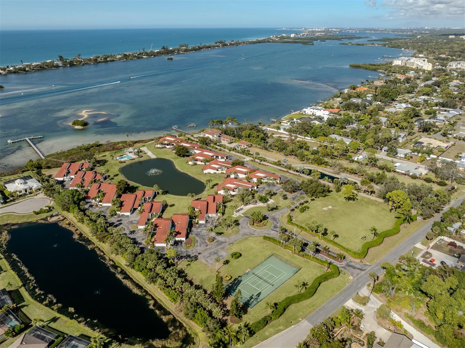 One or more photo(s) has been virtually staged. Live the Florida dream on the water! Wake up to shimmering bay views, spend your days boating and fishing, and end every evening with breathtaking sunsets over Little Sarasota Bay, all from this rarely available, maintenance-free waterfront villa. In the exclusive Heron Bay Club, an intimate bayfront enclave of just 25 villas set across 10 beautifully manicured acres, this home offers the ultimate Florida lifestyle. Enjoy resort-style amenities including a heated waterfront pool, tennis courts, kayak launch, fishing pier, and community docks with water and electric. Best of all, there are 10 free boat slips with no fixed bridges to the Gulf, making this a boater’s paradise, so bring your boat and go! This spacious two-bedroom, two-bath villa features sweeping views of Little Sarasota Bay, the Intracoastal Waterway, the community pond and pool. The open concept floor plan is enhanced by 15-foot ceilings, abundant natural light, and seamless indoor-outdoor living. Relax on the screened lanai, cool off in your heated waterfront pool and enjoy nightly sunsets that never get old. A private gated courtyard entry sets the tone for this unique home, complete with a new paved walkway and pet-friendly artificial turf, completely maintenance-free. Inside, enjoy ES Prestige impact-rated windows and sliding glass doors, all-new kitchen appliances, and an eat-in kitchen overlooking the courtyard. The primary suite offers lanai access through sliding glass doors and features two custom walk-in closets. The second bedroom also opens to the private courtyard and includes its covered lanai, perfect for guests or a home office retreat. Conveniently with quick access to Interstate 75, shopping, dining and beaches, this exceptional waterfront villa delivers boating, fishing, views and effortless Florida living in one remarkable package. A rare opportunity, this is waterfront living at its finest. Schedule your private showing today.