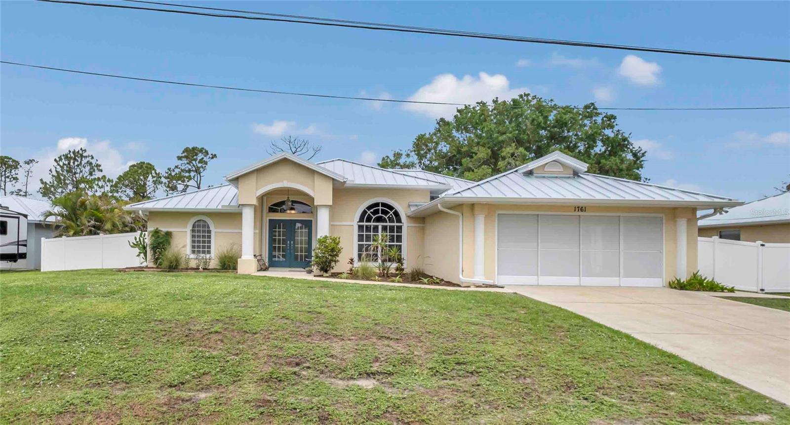 Welcome to your Florida retreat! Nestled on an oversized lot (.46 acre) with mature tropical landscaping in desirable North Port, this beautifully maintained 4-bedroom, 2-bath pool home offers over 2,300 square feet of comfortable living space designed for the Florida lifestyle. From the moment you enter, soaring ceilings, abundant natural light, and views of the heated pool create a warm and inviting atmosphere. The updated kitchen features granite countertops, stainless steel appliances, and an upgraded sink and faucet, while porcelain tile flooring runs throughout the home for easy maintenance. The spacious primary suite offers custom walk-in closets and a recently renovated spa-inspired shower. A split floor plan, two additional bedrooms, and a dedicated office provide flexibility for family, guests, or working from home. Step outside to your private backyard oasis complete with a heated pool, new pool screening, paver fire pit area, lush landscaping, and a fully fenced yard. Car enthusiasts, hobbyists, or anyone needing extra space will love the detached air-conditioned 4-car garage featuring mini-split A/C and three new impact-resistant garage doors. Meticulously maintained with extensive updates, this home offers peace of mind with a standing seam metal roof on both the home and garage (2022), new soffits, gutters, and downspouts, hurricane shutters, generator hookup, updated pool heater, water heater, lighting, LED outlets, smoke detectors, chimney cap, blinds, and more. Pride of ownership is evident throughout. Best of all, this property is not in a flood zone (no flood insurance) and has no HOA or CDD fees. Conveniently located near shopping, dining, golf, parks, and Gulf Coast beaches, this move-in-ready home offers the perfect combination of space, privacy, quality updates, and carefree Florida living.