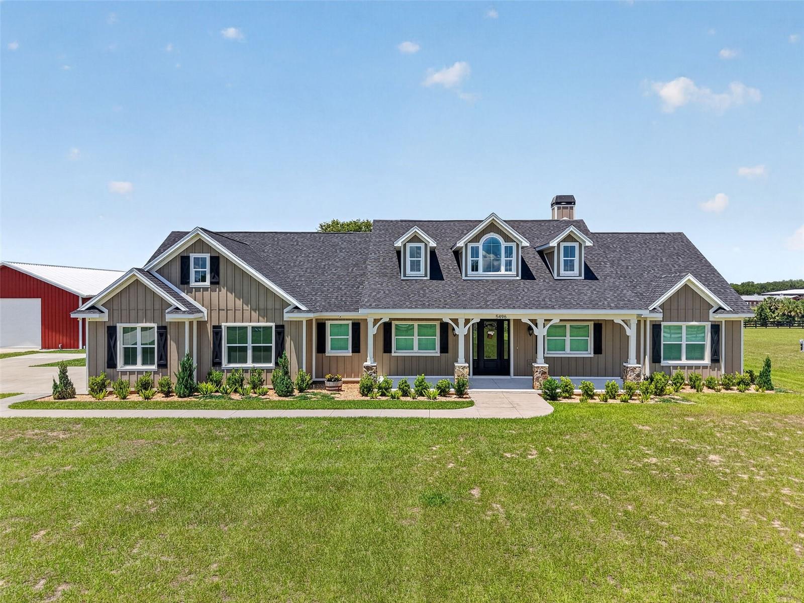 Virtually Staged. Experience the perfect blend of country privacy and modern luxury in this beautiful 3-bedroom 2-bath home, a Workshop 40 X 80, and a 45 KW  DuraWatt Diesel-powered generator with a run time of 3 weeks. An oversized driveway guides you to a grand entrance with incredible curb appeal and a welcoming front porch. Your family will enjoy this 4.66-acre property with stunning views! Upon entering, you will right away fall in love with the dramatic cathedral ceilings and an open-concept floor plan that showcases panoramic views of this large, expansive fenced-in backyard. Make sure you bring your rocking chairs to enjoy the cool breeze on the front porch in the evenings. The heart of the home features a show-stopping 13-foot island wrapped in stone accents, premium wood cabinetry, and a walk-in pantry. Gather in the living room around the magnificent focal-point fireplace, beneath soaring ceilings styled with custom tongue-and-groove woodwork. Attention to detail is most definitely in this home, with tongue-and-groove throughout most of the ceilings. Enjoy this luxury primary suite featuring elegant tray ceilings and a spa-like bath with a claw-foot tub, a walk-in tile and glass shower, and his and hers sinks. From the master bath, you have a view of the pond. The massive walk-in closet includes a custom storage island and offers direct private access right into the laundry room. This split bedroom ensures privacy with the two additional oversized rooms and a bathroom that has his and her sinks, plus a tub/shower combo. Enjoy entertaining in this large and gorgeous back porch with an amazing outdoor fireplace. The home is conveniently located just minutes from all of The Villages' amenities! If you are looking for an amazing custom home, let me assist you and call today! It will be a great place to call home