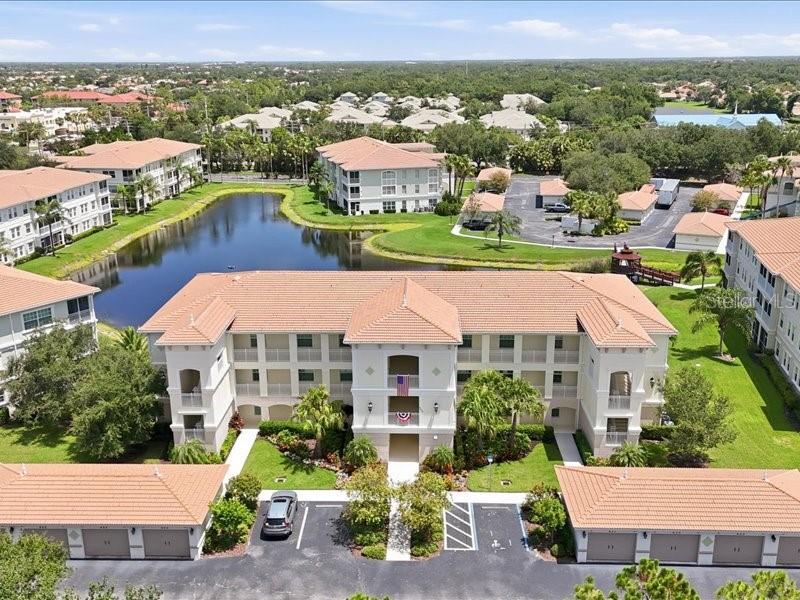 A STUNNING second floor MODEL UNIT located in the highly desirable San Lino community. This spacious second floor, end unit, offers outstanding lake views and is perfectly situated within the San Lino community, and is located within Venice City limits. This community provides easy access to local restaurants, shopping, golf courses and sandy beaches, while remaining just minutes from I-75 and US 41. As a model, this unit features a variety of high end of upgrades, including a wet bar with granite countertops, porcelain flooring, solid wood cabinetry, custom louvered shutters, crown molding, and impact resistant windows and sliding doors. The primary bedroom is an en-suite, with the bathroom having two sinks, two closets and granite counters, and is true luxury. Additionally, this condominium has been meticulously maintained with recent capital improvements, including a new roof (2024), HVAC system (2025), other upgrades are, stainless refrigerator 2026, and a stainless dishwasher 2024, brand new carpet in both bedrooms 2025, and fresh epoxy flooring on the lanai in 2025 for a perfect finished look. Along with all of this, you have a shared 8 x 8 storage unit, a one car detached garage 12 x 19, as well as the extra luxury of an elevator, and as an end unit you have an extra spacious laundry room. As part of this gated community, San Lino residents can enjoy access to an array of amenities such as a clubhouse, a fitness center,  heated pool, lakes, gazebos, sidewalks all on impeccably maintained grounds.