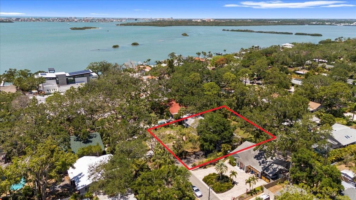 Experience the Best of Florida Living in the Heart of Jungle Prada.  Welcome to this exceptional 2,800-square-foot block home, ideally situated on a rare oversized double lot in the prestigious and highly sought-after Jungle Prada neighborhood of St. Petersburg. Just minutes from award-winning Gulf beaches, waterfront parks, boat ramps, shopping, dining, and vibrant downtown St. Petersburg, this one-of-a-kind residence offers an unmatched combination of space, flexibility, and Florida lifestyle.  Built for both comfort and peace of mind, this home did not flood during the recent hurricanes and is equipped with impact-rated exterior doors and sliding glass doors, along with window shutters for additional storm protection.  From the moment you arrive, you'll appreciate the home's outstanding curb appeal, with mature landscaping, lush tropical gardens, and a welcoming front entrance that reflects true pride of ownership. Inside, natural light fills the expansive open floor plan through oversized windows, highlighting the home's striking contemporary polished concrete floors and spacious living areas designed for both entertaining and everyday living.  The beautifully updated kitchen is the centerpiece of the home, featuring elegant quartz countertops, custom cabinetry, a breakfast bar, and an impressive collection of premium appliances, including a Bosch French-door refrigerator, Bosch dishwasher, Frigidaire induction range with convection oven, wine refrigerator, and Maytag washer and dryer. A natural gas connection is already in place, providing additional flexibility for future kitchen upgrades or outdoor living enhancements.  Privately situated on its own wing, the spacious primary suite offers a peaceful retreat complete with an ensuite bathroom and generous closet space. Three additional bedrooms provide endless possibilities for guest accommodations, home offices, creative studios, fitness rooms, or play spaces.  One of this property's most valuable features is its incredible versatility. The thoughtfully designed floor plan includes two private entrances and two separate driveways, making it ideal as a traditional single-family residence, a multigenerational home, or a property with a private in-law suite. With one Accessory Dwelling Unit (ADU) permitted by the City, buyers also have the opportunity to create a separate income-producing rental or private guest quarters.  Step outside and discover your own tropical sanctuary. The expansive backyard has been thoughtfully landscaped into a private botanical oasis featuring mature Areca palms, coconut palm, mulberry, avocado, papaya, and fig trees, surrounded by more than 100 tropical and native flowering plants and herbs that attract butterflies and colorful birds throughout the year. Whether you're relaxing beneath the pergola, entertaining on the spacious deck, or gardening among the lush landscape, every day feels like a vacation. An irrigation system helps keep the grounds vibrant year-round, and a recent land survey has already been completed for a future pool and spa installation.  Rarely does a property combine this much living space, flexible design, storm resilience, and an unbeatable location just moments from the Gulf beaches. Whether you're searching for your forever home, a multigenerational retreat, or a property with outstanding income potential, this remarkable Jungle Prada residence offers an exceptional opportunity to enjoy the very best of the Florida lifestyle.