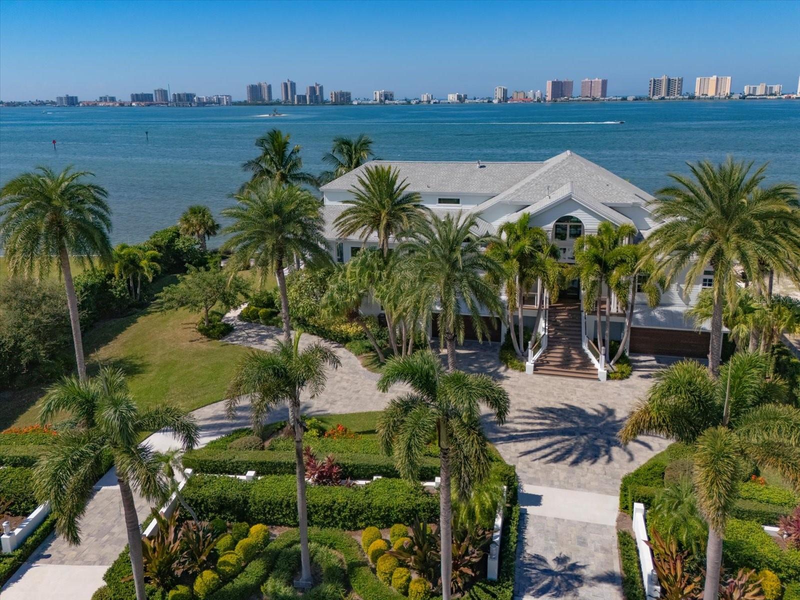 Exclusive Waterfront Estate on Private Belleview Island, enjoy breathtaking open water views and experience the ultimate waterfront lifestyle in this beautifully remodeled  coastal home.  This impeccably designed, and tropically landscaped estate on a double lot sits atop 1.5 acres in the highly sought after, double gated, private island community of Belleview Island with only 31 homes, and 178’ of new seawall. This 5,734sf, 5-bedroom, 5½ bath, 3 story, 3 floor elevator, 5 car garage custom home is the perfect setting for indulgent relaxation or lavish entertaining both inside and outside the home, with wrap around verandas and terraces that capture unobstructed water views. You will immediately take note of the exceptionally fine details, extraordinary appointments and incredible architectural features in this home. The timeless design features clean, open spaces, and places dramatic emphasis on panoramic water views. Outdoor living is truly exceptional, with breathtaking water views, an incredible new outdoor kitchen and bar, a remodeled saltwater pool, lush tropical landscaping, and a vast expanse of lawn. Amazing outdoor spaces are found at every turn to capture glorious sunsets and sparkling water views. Belleair Country Club with world class golf courses are a short walk away.   Savor a life of luxury in this one-of-a-kind island oasis.  ZERO history of water intrusion or flooding!