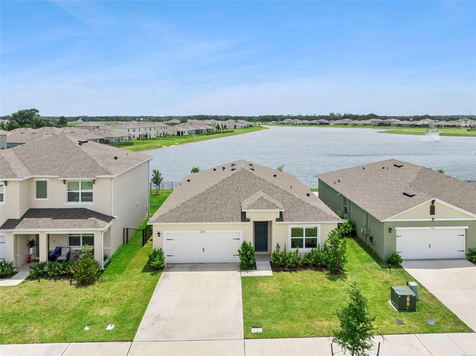 Built in 2025 and loaded with upgrades, this stunning 4-bedroom, 2-bathroom home offers modern living with peaceful pond views and no rear neighbors. Enjoy relaxing mornings and breathtaking sunrises from the covered back porch overlooking the water. Inside, the open-concept design seamlessly connects the living room, dining area, and kitchen, creating the perfect space for entertaining and everyday living. Upgrades include tile flooring throughout, a picture window that fills the living area with natural light, and French doors leading to the backyard and tranquil pond views. The chef-inspired kitchen is both beautiful and functional, featuring quartz countertops, stainless steel appliances, a spacious center island, a dedicated coffee bar, and a walk-in pantry complete with custom built-ins for exceptional organization and storage. Privately situated at the rear of the home, the primary suite serves as a peaceful retreat with pond views and an impressive walk-in closet featuring custom built-ins designed to maximize organization and storage. The ensuite bathroom offers dual vanities and a separate shower, creating a comfortable and private space to unwind. Three additional bedrooms provide flexibility for guests, family, or a home office, while the dedicated laundry room adds everyday convenience. The home also includes smart home technology, allowing you to conveniently control and monitor key features from your smart devices. Residents enjoy access to fantastic community amenities including a resort-style pool, and playground, all with a low HOA. Conveniently located in a growing Central Florida area with easy access to major roadways, shopping, dining, parks, and Downtown Orlando, this move-in ready home offers the perfect blend of comfort, convenience, and modern style.
