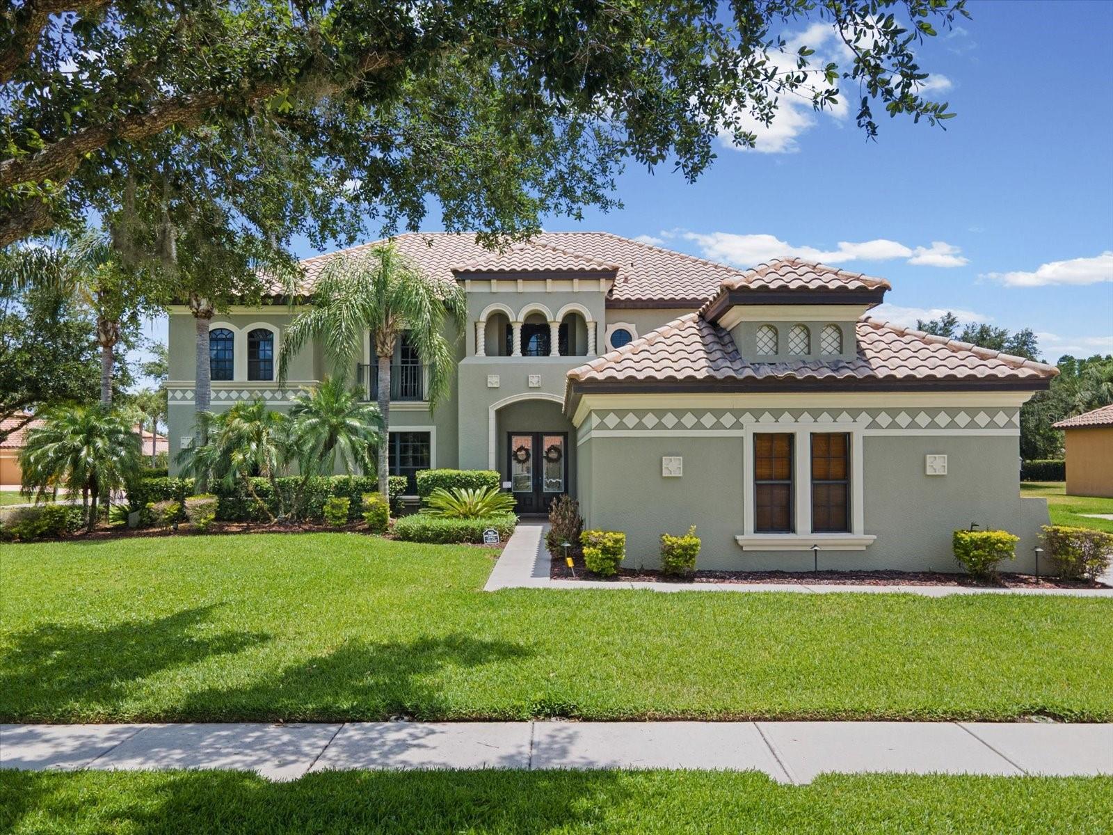 Positioned on a premium .41-acre corner homesite in the sought-after Oakstead GATED community, this 4,277-square-foot residence is designed for the growing family that needs both scale and versatility. With 6 bedrooms, 4 full bathrooms, a dedicated home office/den/6th bedroom, formal living and dining rooms, an expansive loft, and a private theatre room, every need has been accounted for — making this an ideal solution for those upsizing ahead of the new school year.  Leaded glass double doors open into a foyer with a custom mosaic floor, where a double-sided staircase with wrought-iron accents serves as the architectural centerpiece. The main level flows into an oversized family room with a gas fireplace and custom built-ins. The kitchen features 42-inch cabinetry, granite countertops, stainless appliances with a gas range, and a massive center island with a freshly resurfaced butcher block. The breakfast room comfortably fits a family-sized table and overlooks the pool. The first-floor primary suite offers privacy and lanai access, while the renovated en-suite is nothing short of spa-worthy.  With dual vanities and white shaker cabinetry, and a stunning frameless glass walk-in shower wrapped in floor-to-ceiling charcoal slate tile with a ceiling-mounted rain head, handheld wand, and built-in niche. Glass block windows complete the space beautifully. Upstairs, four bedrooms and an open loft surround a theatre room with a balcony overlooking the pool below. The backyard is in a class of its own. A covered lanai that opens to an expansive screened enclosure  (rescreened in 2024) surrounding a freeform saltwater pool with a walk-out entry, heated spa, adding to the resort like atmosphere. Freshly sealed brick pavers provide generous deck space, and professional exterior lighting was upgraded in 2022.  Pool heater 2022. Major systems have been addressed throughout: 3 A/C units replaced between 2021 and 2022, a whole-home generator added in 2025, a new water heater and water softener in 2022, a new washer and dryer in 2025, and LVP flooring in two upstairs bedrooms. Oakstead's resort-style amenities include a pool, tennis courts, clubhouse, trails, and playground — are just steps away. This home offers the space, upgrades, and lifestyle a large family deserves. It won't last long. Schedule your private tour today.