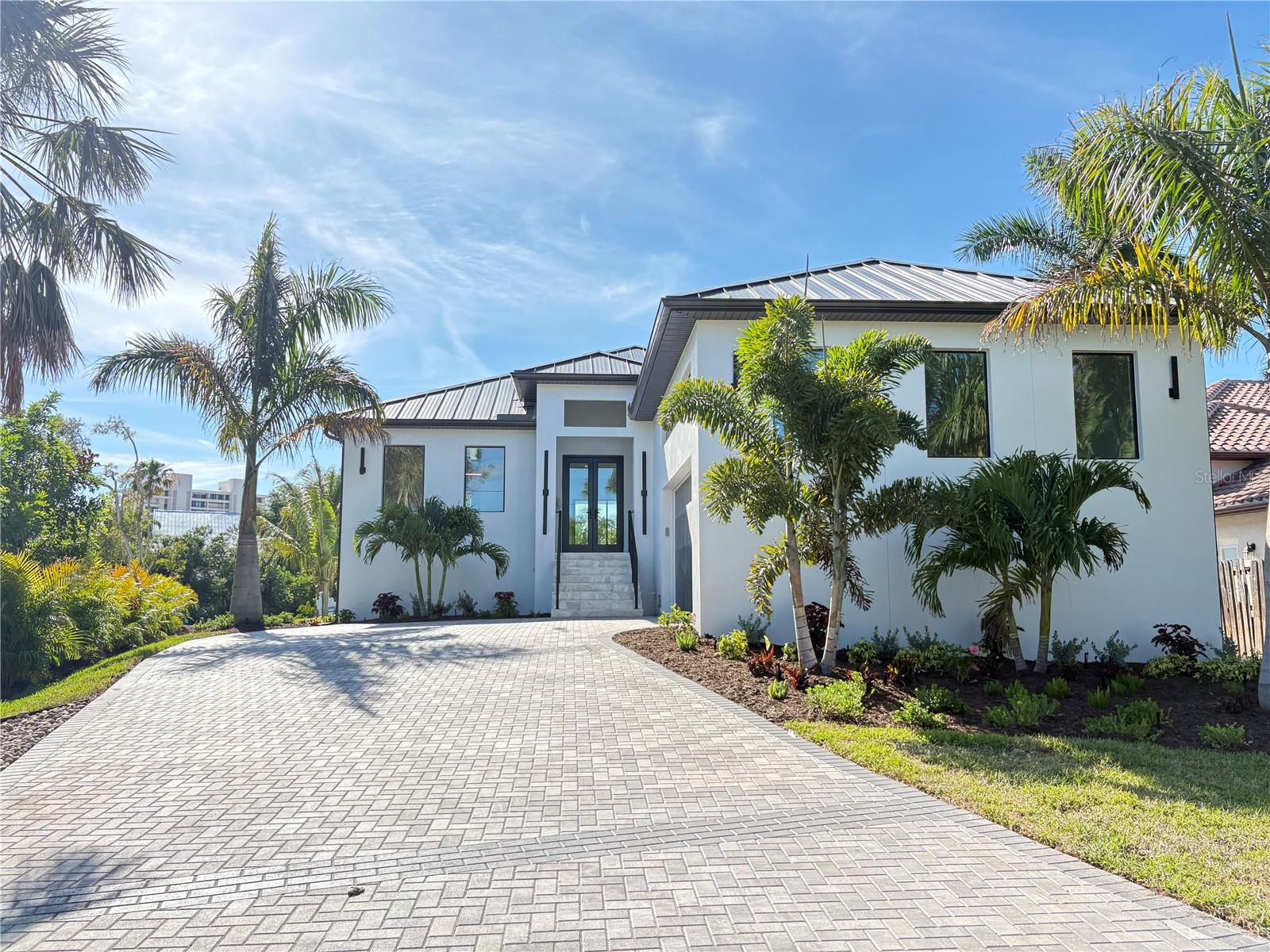 Certificate of Occupancy received 5/27/2026 *Call today to schedule your private showing! Welcome to 276 Island Circle, an exceptional waterfront retreat nestled on an oversized lot in the highly sought-after Palm Island neighborhood of Siesta Key. Perfectly positioned along the Grand Canal and just a half-mile from the world-famous shores of Siesta Key Beach, this beautifully designed 4-bedroom, 3-bathroom residence captures the essence of luxury coastal living.

Thoughtfully crafted with both elegance and functionality in mind, the home offers an open and inviting floor plan highlighted by soaring tray ceilings, abundant natural light, and impressive zero-corner sliding glass doors that seamlessly blend indoor and outdoor living. Impact-rated windows and sliders provide peace of mind while framing picturesque views of the waterfront setting.

The heart of the home is a stunning chef's kitchen designed for entertaining and everyday enjoyment alike. Exquisite quartz countertops and backsplash, dramatic waterfall edges, custom solid wood cabinetry, a Wolf range with custom hood, paneled Sub-Zero refrigerator, paneled Bosch dishwasher, Sharp microwave drawer, hidden outlets, and a showstopping glass-front pantry complete with a wine cooler combine to create a space that is as beautiful as it is functional.

The primary suite offers a private sanctuary with custom-designed his-and-her closets and a spa-inspired bathroom featuring dual vanities, a curbless walk-in shower, and a freestanding soaking tub.

Outdoor living is equally impressive. Overlooking the Grand Canal, the resort-style backyard was designed to embrace Florida's year-round sunshine. Relax in the saltwater PebbleTec pool and spa, unwind on the sun shelf, or entertain guests on the expansive leathered marble paver deck. Boaters will appreciate the impressive, brand new 107 feet of seawall frontage, offering direct access to the waterways that make Siesta Key such a coveted waterfront destination.

Beyond the property, the Siesta Key lifestyle awaits. Spend your mornings walking Siesta Key Beach, consistently ranked among the finest beaches in the world for its powder-soft quartz sand and crystal-clear Gulf waters. Enjoy afternoons exploring Siesta Key Village's collection of boutique shops, waterfront restaurants, lively cafés, and local entertainment. Whether boating, dining al fresco, watching spectacular sunsets, or simply enjoying the laid-back island atmosphere, every day feels like a vacation.

Rarely does a home combine a premier Palm Island location, exceptional waterfront setting, luxurious finishes, and close proximity to Siesta Key Beach so effortlessly. 276 Island Circle offers a unique opportunity to experience the very best of Sarasota's island lifestyle.