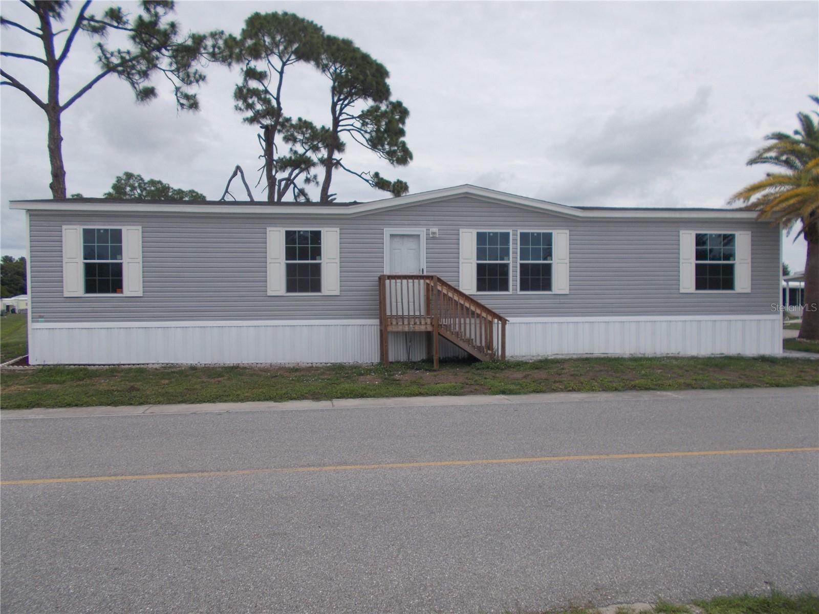 Holiday Park - Why wait months to build, when this 3 bedroom, 2 bath furnished Doublewide, located in the Gated Community of Holiday Park and in the PET SECTION, is ready for you to occupy. Built in 2025 this home boasts 1560 square feet of living space.  The kitchen has an island, you have a dining room and both a living room and a family room.  It also has a split floor plan with the primary bedroom on one side and the other 2 bedrooms on the other.  The washer and dryer are located off the kitchen. The 10 X 10 shed located at the end of the carport. In Holiday Park you own the land with a deed and your $195.00 monthly maintenance fee ($2340.00 a year) is included in your taxes. The community features 2 clubhouses, 2 swimming pools, a library, a fitness room, tennis courts, pickleball & bocce courts, to name a few. You are close to shopping, dining, entertainment, numerous golf courses, sports facilities, and SW Florida's renowned beaches. Come take a look!