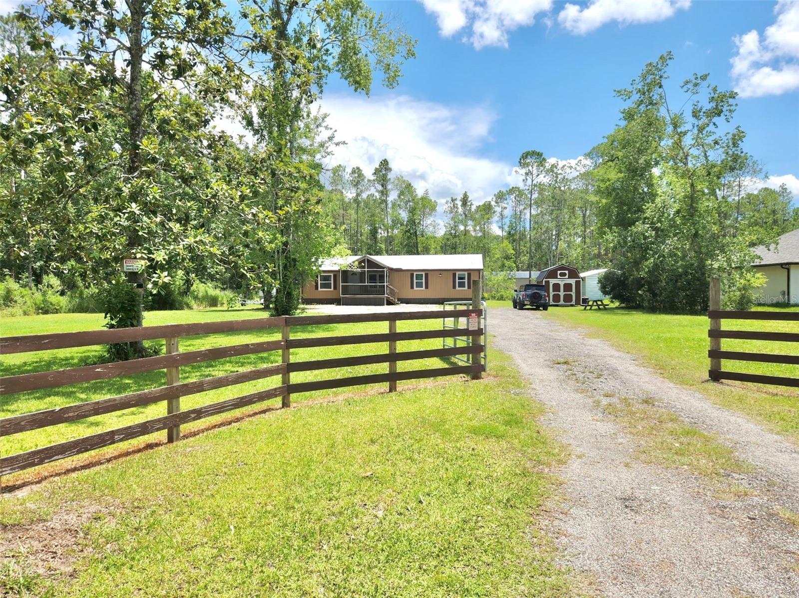 Come View this Beautiful updated Three Bedroom with Two bathrooms on 1.4 acres. The home has wood siding and a Metal roof that has a life estimated at 40 to 60 years. The AC and water heater were installed just over two years ago. The Screen front Porch offers a relaxing place to enjoy the quiet surroundings. The Property Combines Beauty with a variety of fruit trees plus blueberry bushes and raised gardens for your fresh Vegetables and Flowers. Included with the property  are Two outside Storage Sheds providing you with ample space for tools, gardening supplies and outdoor equipment. You walk thru the front door to a warm open concept that is laid out and designed for everyday living. The Split bedroom floor plan provides added privacy with the primary suite on one side and the other two bedrooms on the other side of the home. The Highlights include a Wood burning fireplace, generous storage with a large walk in pantry and a Laundry room with a washer and dryer. The Lage Kitchen with Modern Cabinetry, Stone Countertops, and features appliances just over 2 years old. All the appliances convey with the sale. This Piece of Paradise is on your own land with Privacy. Schedule your Showing today.