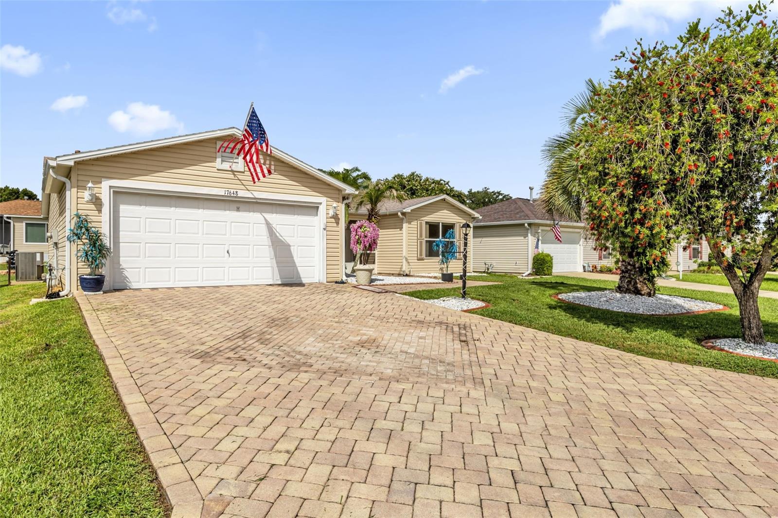LOW BOND!! Welcome to this beautifully maintained 3-bedroom, 2-bath split-bedroom home, offering exceptional curb appeal and numerous valuable updates. From the moment you arrive, you’ll appreciate the brick paver driveway and walkway, enhanced landscaping accented with decorative white rock beds, and a welcoming screened front porch. Inside, the open floor plan features volume ceilings, abundant natural light, and ceramic tile and wood laminate flooring throughout—no carpet! The split-bedroom layout provides privacy with the spacious owner’s suite separated from the guest bedrooms. The kitchen offers classic whitewashed maple cabinetry, a decorative tile backsplash, a gas double oven, side by side refrigerator, and an open design that flows seamlessly into the living and dining areas. Just beyond, the enclosed tiled lanai creates additional year-round living space perfect for relaxing or entertaining. This area has its own mini split system for heating and cooling. The garage is equally impressive with attractive red and black RaceDeck flooring, providing a clean, finished look for your vehicles, golf cart, or workshop. Major mechanical updates provide peace of mind, including a 2025 A.O. Smith 40-gallon natural gas water heater, a HALO H2Zero whole-house water conditioning system, a Lennox HVAC system, and a 2021 architectural shingle roof. Even better, the bond balance is under $1,400, allowing the new owner to enjoy significant future savings. This is a wonderful opportunity to own a well-cared-for home that combines thoughtful updates and outstanding curb appeal.