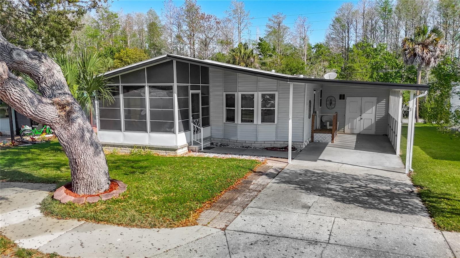 A POPULAR 55+ COMMUNITY WHICH HAS A POOL, CLUBHOUSE, SHUFFLEBOARD, & ACTIVITIES FOR ONLY $90 MONTH. This lovely 2-bedroom, 2-bathroom home has vaulted ceilings, and Themo windows that pull out for easy cleaning, & a "FOREVER ROOF" (A "forever roof" on a manufactured home refers to a roofing system that is designed to last for a long period.) A covered, enclosed 11X22 workshop/shed with electric, washer & dryer, and also has room to park a golf cart or motorcycle inside that space. The central A/C Heat is a Grand Aire 2015, & a 2-car carport 11X29. All furniture, & tools included. Pets are welcome, which it's hard to find a HOA that accepts 2 pets! You own your land, & the location is tucked away but close to all the conveniences like shopping, restaurants, medical, entertainment, beaches, springs, parks, about 5 minutes to Spring Hill, 15 mins to Weeki Wachee, 25 minutes to Tarpon Springs & 50 minutes to Tampa International Airport.