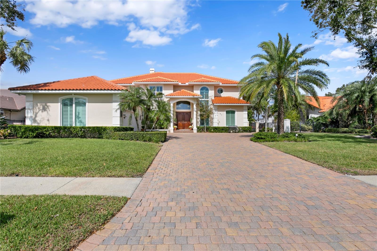 Experience exceptional waterfront living in the gated community of Pelican Island! This spacious two-story residence offers 6 bedrooms, 5 baths, 3 car garage, and approximately 5,345 square feet of thoughtfully designed living space. The home welcomes you with a grand staircase and abundant natural light throughout. The expansive family room features a fireplace, built-in wet bar, and soaring ceiling open to the second floor. A cozy den and a climate-controlled 450+ bottle wine room sit just off the family room, creating an ideal layout for relaxing or entertaining. The formal dining room provides an elegant setting for special gatherings. The large kitchen is well appointed with solid wood cabinetry, a generous island, granite counters, double ovens, a induction cooktop, and a spacious dining area overlooking the water. Downstairs also includes an office with a walk-in closet, and 2 guest bedrooms with adjacent full baths. A catwalk above the family room leads to the upstairs bedrooms, including the primary suite, where peaceful views of the mangrove preserve and canal create a serene retreat. The suite includes dual walk-in closets and a well-designed bath with a double vanity, garden tub, separate shower, and water closet. Three additional bedrooms complete the upper level; two share a Jack-and-Jill bath, each featuring its own walk-in closet. Outdoor living is a highlight, with a large pool, outdoor kitchen with smoker, and a dock equipped with a 10,000-lb boat lift. Enjoy quick boat access to the open waters of Old Tampa Bay and beautiful sunset views each evening. The backdrop of lush mangrove preserve and the wide canal ensures privacy and natural beauty. Pelican Island is a gated waterfront neighborhood of custom homes located minutes from Berkeley Preparatory School, Tampa International Airport, International Plaza, the Westshore Business District, and Downtown Tampa. Nearby Skyway Park offers a playground, tennis courts, and athletic fields, along with trail access to the Courtney Campbell Pedestrian Bridge. Rocky Point Golf Course is just across the street. This home combines comfort, space, and an exceptional waterfront lifestyle in one of Tampa’s most desirable locations!