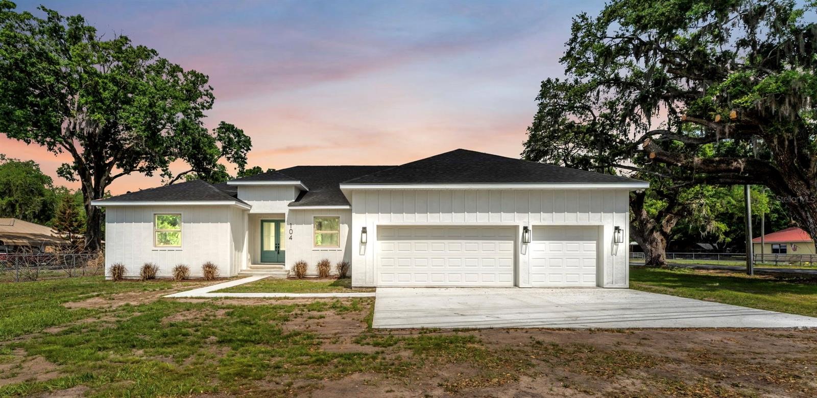 Situated on a corner lot in Plant City, this newly built 4-bedroom, 3-bathroom home combines modern design with a spacious, move-in-ready feel. The three-car garage, oversized driveway, and mature trees create standout curb appeal, while the open layout inside is designed for both comfort and entertaining. The main living area features exposed wood beams, recessed lighting, a custom accent wall with a sleek linear fireplace, and large sliding glass doors leading to the backyard. Just off the foyer, a private office or flex room with French doors adds extra versatility.

The kitchen is both stylish and functional with a large quartz island, sleek cabinetry, pendant lighting, built-in oven, walk-in pantry, and a secondary prep area with its own sink, extra countertop space, and a built-in wine fridge. The primary suite includes wide plank flooring, two walk-in closets, and a beautifully finished en-suite bath with dual vessel sinks, quartz counters, floor-to-ceiling tile, and a rainfall showerhead. Secondary bedrooms and bathrooms continue the home’s clean, modern style.

Additional highlights include a mud area with built-in storage, spacious laundry room with utility sink, land, and no HOA. This home blends modern living with privacy and convenience. Schedule a showing today!
