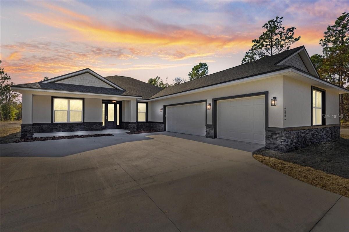 Under Construction. Why settle for someone else’s selections when you can still choose your own? This under-construction 3-CAR GARAGE home-photos are from a previous model. The Tranquility floor plan offers a rare opportunity to secure over 1 acre and still personalize select finishes before construction is complete. Scheduled for August 2026 completion, buyers still have time to choose granite countertops and flooring to create a home that reflects their style from day one. Vaulted ceilings and abundant natural light create an open, airy feel, while the split-bedroom layout provides comfort and privacy. The spacious primary suite features a tray ceiling, dual walk-in closets, A SOAKING TUB and a large walk-in shower. The kitchen is designed for everyday living and entertaining with granite countertops, tiled backsplash, a large center island, 42” soft-close cabinetry, stainless steel appliances, range hood and a pot filler faucet. Off the kitchen is a MUDROOM with an oversized walk-in pantry, laundry room with a granite countertop folding bar and a HALF BATHROOM that's great for visitors. A PRIVATE OFFICE with French doors makes working from home easy. Step outside to the OVERSIZED 26’ x 12’ COVERED LANAI overlooking your private acreage—perfect for relaxing, entertaining, or simply enjoying the peaceful Florida lifestyle PLUS A COVERED FRONT PORCH. Builder financing incentive available through the preferred lender. Photos and video contain buyer-selected upgrades shown for illustration purposes, including an expanded driveway/RV pad, stone veneer front elevation accents, garage utility sink, larger living room windows, shower niche, and luxury vinyl plank flooring in bedrooms. Schedule a showing today!