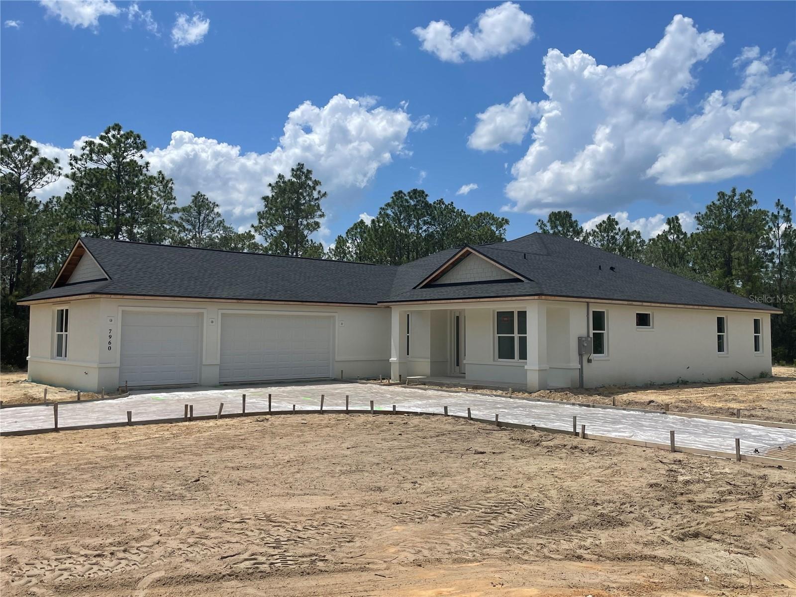 Under Construction. AUGUST MOVE-IN ON 1+ ACRE FOR UNDER $500K! Why wait 8-12 months to build when this brand-new Tranquility floor plan is already under construction and on track for an August 2026 completion? Offering over 2,300 square feet of thoughtfully designed living space, this 3-bedroom, 2.5-bath home with a dedicated OFFICE and 3-CAR GARAGE delivers the space buyers are searching for without sacrificing style, functionality, or privacy. Inside, vaulted ceilings and abundant natural light create an open, airy feel. The split-bedroom layout provides separation between the owner’s retreat and guest bedrooms, while French doors lead to a private OFFICE ideal for working from home, hobbies, or a flex space. At the heart of the home, the kitchen is designed for everyday living and entertaining with granite countertops, a large center island, tiled backsplash, 42” soft-close cabinetry, stainless steel appliances, a range hood, pot filler, and plenty of storage. A true standout feature is the OVERSIZED MUDROOM area complete with true walk-in pantry, laundry room with granite folding counter, and convenient HALF BATH—creating the organization and functionality today’s buyers love. The owner’s suite is a private retreat featuring tray ceilings, dual walk-in closets, a relaxing soaking tub, dual granite vanity and a spacious walk-in shower. Step outside to enjoy Florida living from the welcoming FRONT PORCH or the expansive 26’ x 12’ COVERED LANAI WITH CEILING FANS AND LIGHTING overlooking your private acreage homesite with room to spread out and enjoy the outdoors. Construction remains on schedule for an August 2026 Certificate of Occupancy. Photos 1-8 were taken June 24, 2026. Remaining photos and video are from a previously completed Tranquility model and may include optional buyer-paid upgrades shown for inspiration, including an expanded driveway/RV pad, stone veneer accents, utility sink, larger living room windows, shower niche, and luxury vinyl plank flooring in bedrooms.  The builders lender offers incentives.