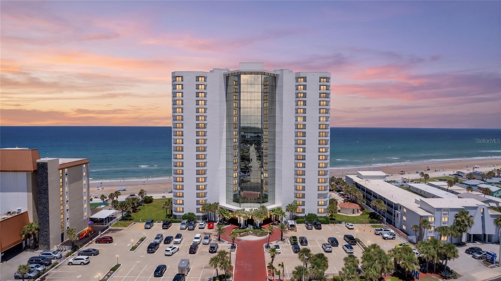 Welcome to the Caribbean Condo luxury ocean front lifestyle in beautiful Daytona Beach Shores, where the Atlantic Ocean is your backyard! This beautifully completely remodeled 2-bedroom, 2-bath condominium is located on the 4th floor and offers spectacular ocean views while overlooking the tropical heated pool. With 1,380 square feet of living space, this move-in-ready condo comes completely furnished and is perfect as a primary residence, vacation home, or investment property. The spacious floor plan features an extra-large balcony accessible from both the living room and primary bedroom, providing the perfect place to enjoy breathtaking sunrises, pool views, and the ocean breeze. Interior upgrades include wood-look plank ceramic tile throughout, fresh paint, all new lighting with ceiling fans, a 2024 HVAC system, and a modern induction range with built-in air fryer and all new premium kitchen appliances. This well-maintained oceanfront building offers outstanding resort-style amenities, including a stunning atrium lobby, scenic glass elevators, a spectacular 19th-floor penthouse club room with panoramic ocean and river views, a newly updated fitness center, billiards room, indoor hot tub, sauna, and updated restrooms. The oceanfront heated pool is thoughtfully positioned to enjoy sunshine throughout the day and features outdoor grills for entertaining. Additional conveniences include secure underground parking, a private storage unit, bicycle storage, motorcycle parking, an on-site property manager, and a new roof installed in 2026. Internet and Spectrum cable are included in the association dues for added value. Ideally located right on the beach and close to shopping, restaurants, entertainment, and I-4, this exceptional condominium offers the perfect combination of luxury, convenience, and coastal living. Don’t miss your opportunity to own your own piece of paradise!