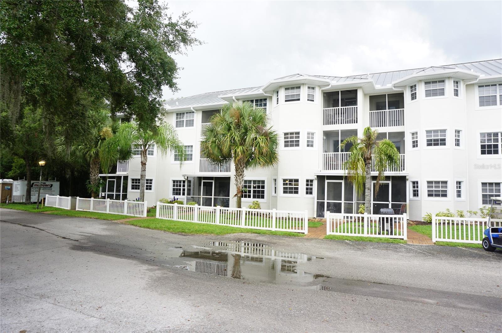 Under contract-accepting backup offers. Enjoy ground-floor convenience in this furnished 1-Bed/1-Bath condo located in the gated nudist/clothing-optional community of Paradise Lakes. This lovely home has an open floorplan with tile/wood laminate flooring throughout. The spacious kitchen features plenty of cabinets and counter space, pantry storage, refrigerator (2018), built-in microwave (2023), 4-burner range (2023), dishwasher (2022), disposal (2022), bay window, and breakfast bar. The living room has comfy furnishings including a sleeper sofa for guests, 55" Smart TV, and custom textured wall. The floorplan includes a dining space with view of the common area and pickleball courts. The primary bedroom has a king bed, walk-in closet, custom textured wall, 55" Smart TV, and sliding doors to the covered/screened/tiled walk-out lanai. The bath has a dual-sink raised vanity and tile-surround walk-in shower with glass block accent. Indoor laundry room with full-size washer (2024), dryer (2021) and lockable storage closet. AC is dated 2022. Water heater replaced in 2020. One assigned covered parking space conveys with the unit. Buyer is responsible for verifying all information, details, and dimensions. Condo association approval of Buyer is required including application, fee, background check, and membership in a recognized nudist organization. Optional membership to Paradise Lakes Resort is not included in the monthly condo association fee.