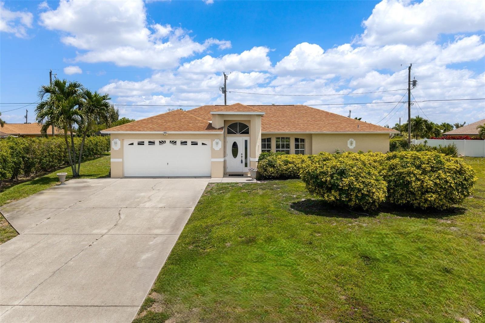 Nestled at the end of a quiet road on an oversized triple lot, this beautifully maintained 3 bedroom, 2 bath home offers the perfect blend of space and comfort. The kitchen is sunlight filled and features an expansive counter space, updated cabinetry, a breakfast bar, pantry, and direct access to a laundry room with utility sink. Pocketing sliding glass doors extend the living space to the lanai, creating a seamless indoor/outdoor experience. The primary suite is generously sized with private lanai access, two walk-in closets, and an updated ensuite bath complete with a beautifully tiled shower, modern vanity, and a private water closet. Two spacious guest bedrooms share an updated bath with convenient lanai access - perfect for future pool plans. Additional highlights include a 2020 roof, tile flooring throughout, new blinds, a new front entry door, and full hurricane shutter protection. The expansive yard offers irrigation, plenty of room to play, and a fenced dog run for your furry friends. Located in desirable Southwest Cape Coral, this home is tucked away in a quiet neighborhood while still being just minutes from shopping, dining, and everyday conveniences.