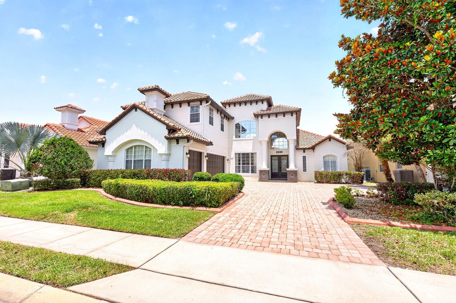 Experience LUXURY LIVING in this stunning 5-bedroom, 4-bath estate home in the highly sought-after Greens at Providence, an impressive 24-HOUR GUARD-GATED golf community in Davenport. Offering over 4,000 SQUARE FEET of beautifully designed living space, this exceptional residence combines ELEGANT ARCHITECTURE, generous living areas, and resort-style outdoor living in one unforgettable package. From the OUTSTANDING CURB APPEAL, featuring a brick paver driveway, mature trees, lush landscaping, and a SPACIOUS 3-CAR GARAGE to the BREATHTAKING ENTRANCE, highlighted by a dramatic 30-foot ceiling, this first impression sets the tone for the elegance found throughout the home. BEAUTIFUL CERAMIC TILE FLOORING flows throughout the main living areas, while CUSTOM WINDOW MOLDINGS (2020) enhance the home's refined character. The formal Living Room is both elegant and inviting, featuring a COZY FIREPLACE and FRENCH DOORS that open directly to the outdoor living space. Nearby, the formal Dining Room is framed by large windows that fill the room with NATURAL LIGHT and provide lovely views of the front landscape. At the heart of the home is a spacious Kitchen designed to impress. An ABUNDANCE OF CABINETRY and GRANITE COUNTERTOPS provide ample workspace, while features such as a center island, tile backsplash, closet pantry, extended breakfast bar, and stainless steel appliances—including a SAMSUNG SMART REFRIGERATOR (2023)—make it as functional as it is beautiful, and a SUNLIT BREAKFAST NOOK offers peaceful views of the pool and patio area. The Kitchen flows seamlessly into the EXPANSIVE FAMILY ROOM, where numerous windows and FRENCH DOORS flood the space with natural light. Two bedrooms are conveniently located on the main floor, each featuring NEW ENGINEERED HARDWOOD FLOORING (2024) and walk-in closets. The luxurious Primary Suite serves as a private retreat with dual closets, FRENCH DOORS that lead to the patio and pool area, and a SPA-INSPIRED EN SUITE BATH featuring a tray ceiling, dual vanities, a jetted garden tub, walk-in shower, and private water closet. Ascend the STUNNING STAIRCASE to discover three additional bedrooms, both with NEW ENGINEERED HARDWOOD FLOORING and walk-in closets. One functions as a SECOND PRIMARY SUITE with its own PRIVATE EN SUITE BATH, making it ideal for guests or multi-generational living. A large bonus room with BUILT-IN SHELVING offers endless possibilities as a game room, media room, loft, home office, or playroom. Experience ultimate relaxation in your backyard sanctuary, complete with a SCREENED-IN HEATED POOL, soothing spa, and a NEW POOL HEATER (2023), all while taking in SCENIC VIEWS of the Providence Golf Club's picturesque water feature.Residents of Providence enjoy an INCREDIBLE ARRAY OF AMENITIES, including a championship golf course, clubhouse, fitness center, resort-style pools, water park, playgrounds, walking trails, tennis courts, and 24-hour guarded security. Conveniently located, you'll be near WORLD-FAMOUS ATTRACTIONS like Walt Disney World Resort and Universal Orlando Resort, as well as shopping and dining in the nearby, rapidly growing CHAMPIONSGATE AREA.This extraordinary home provides the perfect combination of luxury, comfort, space, and RESORT-STYLE LIVING—a truly exceptional opportunity that must be seen to be fully appreciated. Call and schedule your tour today!