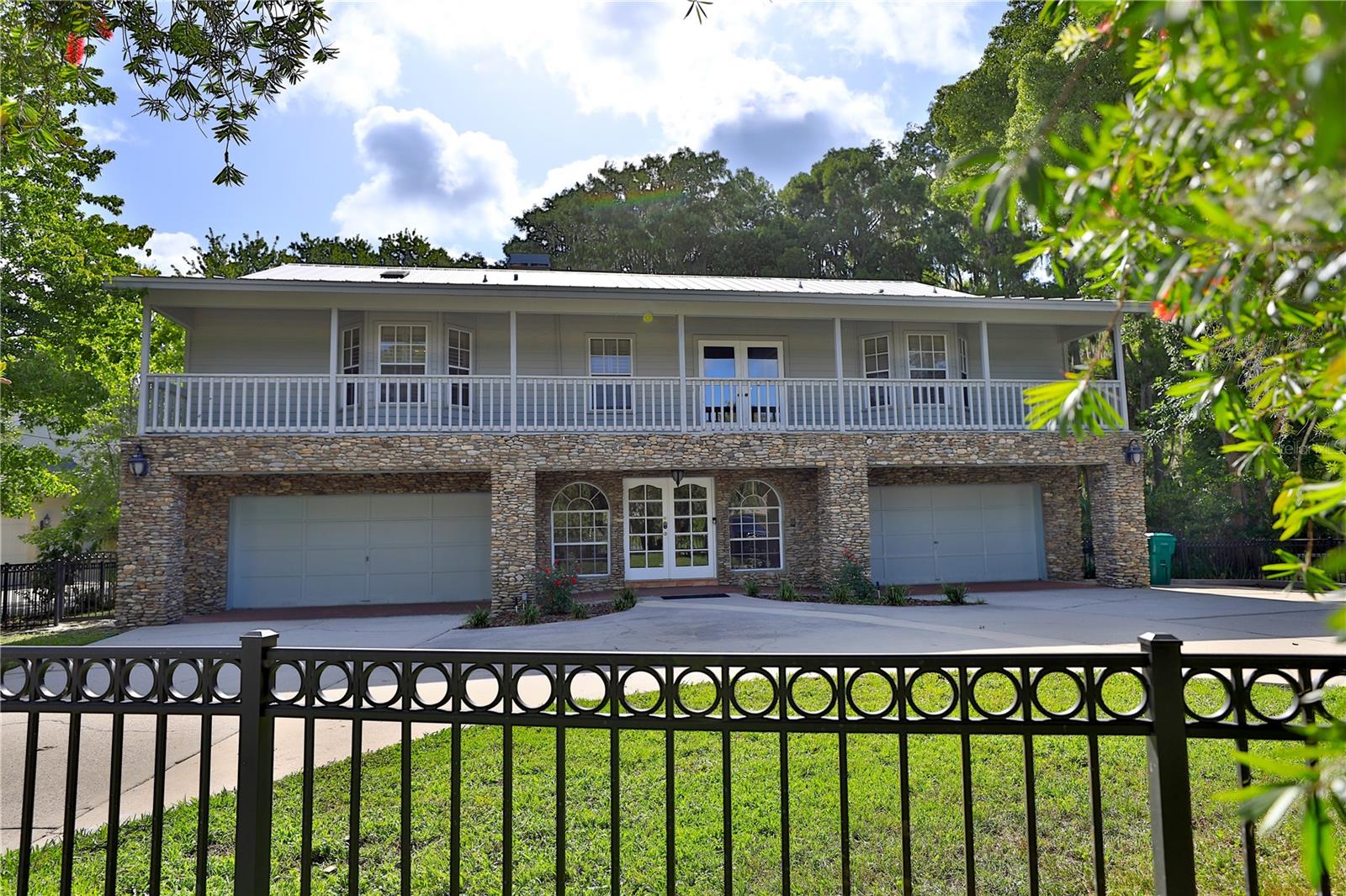 A rare opportunity to own one of Rainbow River’s premier waterfront estates. Experience unparalleled luxury where timeless elegance meets one of Florida’s most breathtaking natural settings. This exceptional 6,040± square-foot residence boasts approximately 90 feet of private Rainbow River frontage, offering unobstructed views of the crystal-clear, spring-fed waters. With no homes across the river—only the untouched beauty of Florida’s natural landscape—this extraordinary property delivers a level of privacy and serenity that is truly unmatched.
Thoughtfully designed to capture the spectacular views, the home features two expansive screened porches spanning both levels, along with a private balcony off the owner’s suite, creating the perfect setting to enjoy peaceful mornings, colorful sunsets, and the beauty of the river throughout the day.
A grand foyer welcomes you inside, where an elegant staircase and custom elevator provide access to the main living level. The impressive great room showcases soaring vaulted ceilings, a stately fireplace, custom wet bar, and walls of glass that frame the river beyond. French doors open seamlessly to the screened porch, blending indoor and outdoor living. The gourmet kitchen flows effortlessly into the dining area, creating an ideal space for both intimate gatherings and grand entertaining.
The owner’s suite is a private sanctuary featuring its own fireplace, sitting area, and secluded porch overlooking the river. The spa-inspired bath offers a soaking tub, walk-in shower, private water closet with bidet, dual vanities, and two generous walk-in closets. Two additional guest suites, each with private en-suite baths, provide exceptional comfort and privacy.
The lower level is equally impressive, featuring an expansive game room with a built-in bar and custom cabinetry, along with a spacious flex room complete with a closet and utility sink—ideal as an art studio, fitness room, home office, media room, or additional guest suite. An additional bedroom and full bath make this level perfectly suited for extended family, guests, or multigenerational living.
Two oversized garages provide space for up to four vehicles, while the conveniently located upstairs laundry room enhances everyday functionality.
Outside, approximately 90 feet of private Rainbow River frontage sets the stage for an extraordinary waterfront lifestyle. A spacious deck leads to the private dock, offering immediate access to boating, kayaking, paddleboarding, fishing, swimming, or simply floating along one of Florida’s most celebrated spring-fed rivers. A tranquil waterfall feature and beautifully landscaped grounds complete this remarkable outdoor retreat.
Combining architectural elegance, exceptional craftsmanship, and one of the most coveted locations on the Rainbow River, this extraordinary estate offers an unparalleled opportunity to experience the very best of Florida waterfront living.