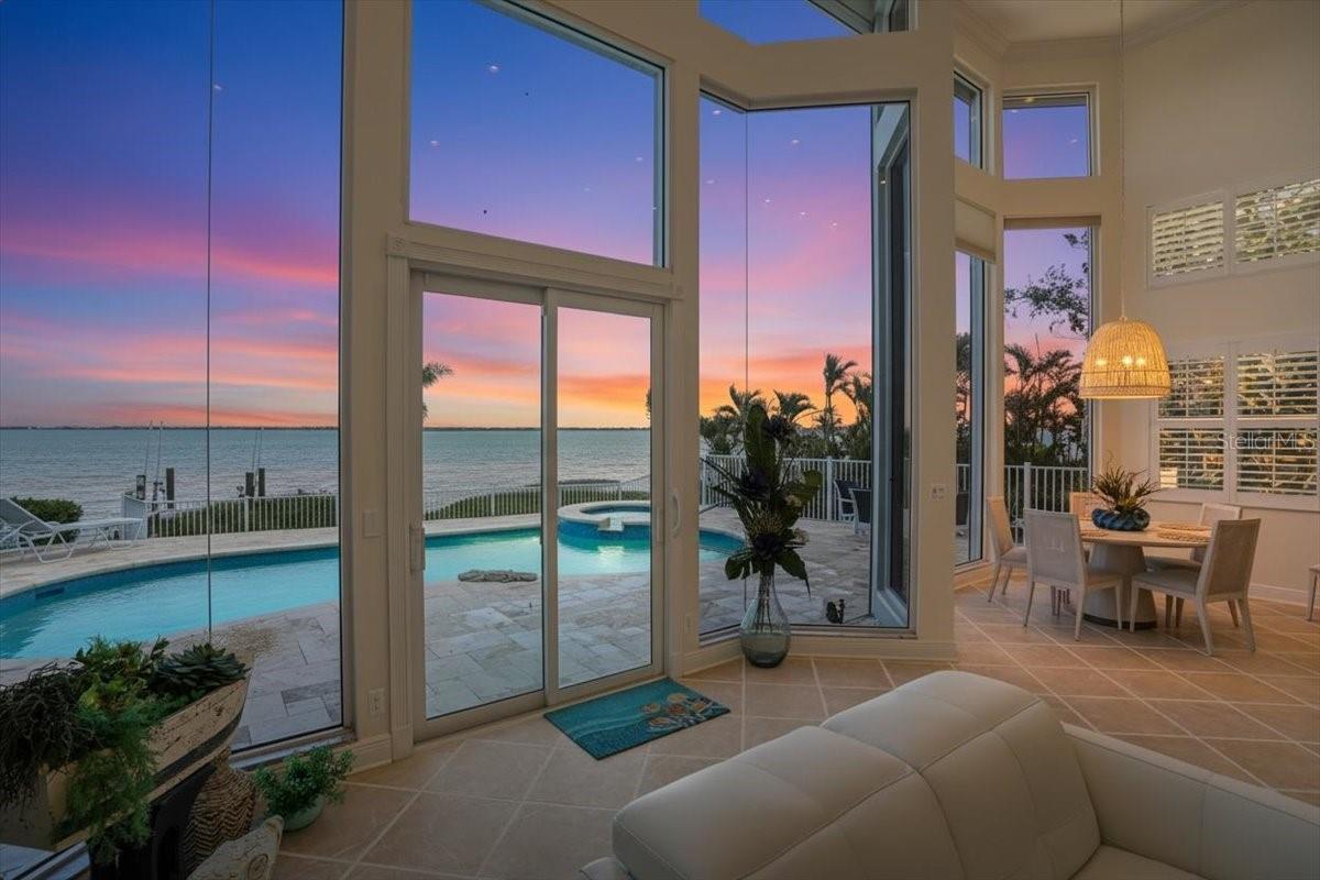 Under contract-accepting backup offers. PCATTO!  PAY CLOSE ATTENTION TO THIS ONE!  There is so much to take in, so let’s start with some bullet points: DIRECT BAY BIG,BIG,BIG WATER VIEW. PRIVACY.  5BED/4.5BATH HOME. ELEVATOR. ALL NEW- DOCK WITH 16,000 LB. LIFT, ROOF, SKYLIGHTS, GUTTERS, OPERATIONAL WINDOWS, DOORS, SHUTTERS (FOR BAYFRONT FIXED WINDOWS), TRAVERTINE POOL DECK, GUNITE POOL SURFACE, FENCE, LANDSCAPING, EXTERIOR PAINT.  The work is done for you! Landscaped with privacy in mind and positioned in the cul-de-sac as the last home on the direct Bay in lovely Queens Harbour.  The outward attraction of this home will immediately drive your desire to explore further.  And, once you enter thru the double glass entry, the exhilaration will overtake you.  Bay views abound thru the wide-spread wall of glass that encompasses the common living areas of dinette, kitchen, living room, primary bedroom and bonus rooms.  Sky-high ceilings and coastal flooring add to the wonder of this show-place and the fixtures that have been added define the finest of taste.  Primary, 2nd and 3rd bedrooms, three full baths, as well as all common space (kitchen, dining, dinette, living room, family room), complete the first level of this home and upstairs you will find two more bedrooms, a bath, and flex space- ELEVATOR OR STAIRCASE ACCESSIBLE.  The inside will amaze, but let’s be real- outside living is what Longboat Key is all about.  Savor the sunrise from your private dock and ease into the day, poolside.  Hop in the boat to head out for a sunset ride to your favorite waterfront dining spot and wrap up with a cocktail in the spa as you admire the stars and Sarasota lights across the Bay.  Feel like the beach?  Great!!  You can do that too because with this home you are a part of Bay Isles which includes the private Beach Club and also provides an added sense of security with guarded and double-gated entry to your community.