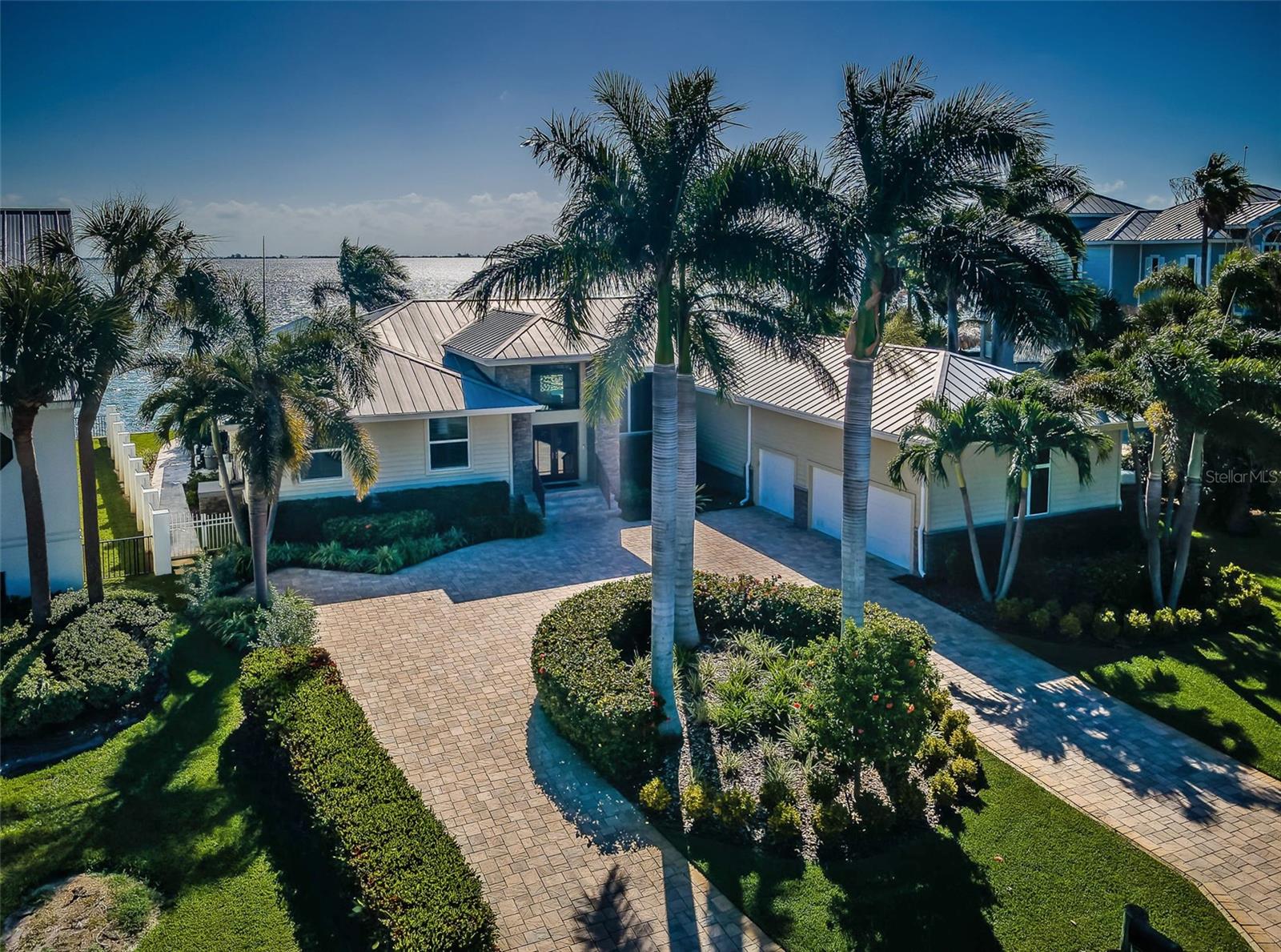 THIS REMARKABLE 4 BEDROOM LUXURY RESIDENCE, WITH ITS IMPRESSIVE 155FT OF SEAWALL AND ASTOUNDING BACKYARD BOATING, DINING AND RECREATIONAL PARADISE, DELIVERS MAJESTIC OPEN WATER VIEWS OF THE SUNSHINE SKYWAY BRIDGE. Lushly landscaped with a finely-pavered circular driveway, rich flatstone  exterior finishes, 14ft-high covered entry and 15ft high foyer, welcome to a residence with dazzling unobstructed waterviews that span the width of this amazing home. A grand great room plan features 12ft-high vaulted ceilings, built-in entertainment center and surround sound. The exquisite chef’s kitchen boasts a wonderful island bar with beverage chiller/prep center, high-quality stainless-steel appliances including Subzero refrigeration, a custom pass-thru storage hutch, elegant granite surfaces/backsplash areas and extensive cabinetry storage. You’ll love the family room and its sweeping views of the waterfront. The gorgeous owner’s suite offers incredible water views, two roomy walk-in closets with closet systems, a private waterfront deck and dedicated access to the pool deck. Your owner’s bath is a pampering retreat with luxe free-standing soaking tub, glass-enclosed rain-shower with multiple shower heads, and two superb quartz vanities with a matching built-in linen/dresser. Second and third bedrooms are generously-sized with fine closet systems, while the second and third full baths are both gracefully in their appointments and tastefully-finished. The 4th bedroom is set up as an executive office with exceptional built-in furnishings. Step out back to a rare waterfront spectacle: The 370sqft covered lounging deck transitions to a stunning Pebbletec infinity pool/spa with in-pool lounging area and specialty waterfall effects, and built-in Tucci SS umbrella. Thick travertine pavers meander throughout the deck and sitting areas. The built-in luxury outdoor gas kitchen supports a dedicated built-in pool bar. Built-in gas firepit is complemented by a large built-in seating area. The composite boat dock setup is truly incredible, with 30K lb boat lift (accessible from three sides), 7K lb dual jetski platform lift, step-down area for kayak/paddleboard launch, mooring for a deep water cruiser, and extensive lighting, power and water. The list of features/capabilities of the outdoor waterfront area of this home make it an entertainment marvel. Exquisite marble floors, lavish woodworking, splendid specialty window treatments, whole-house water filtration/softening system, central vacuum, whole-house backup gas generator, extensive landscaping, 3 car garage with built in cabinetry and so much more. This is a magnificent home and extraordinary waterfront living experience in one of Florida’s best waterfront and boating communities. Flood policy is assumable at $1,170/yr. Dimensions are estimates, buyer to verify.