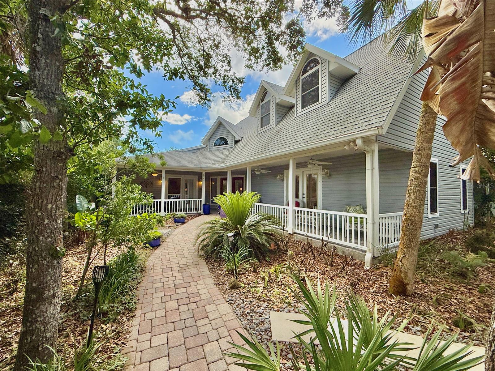 Welcome to your beachside retreat in golf cart–friendly Flagler Beach, where coastal charm, privacy, and character come together. Tucked deep on the lot beneath beautiful live oak trees, this custom-built home offers a peaceful setting with shade, privacy, and the sound of waves nearby. The inviting wraparound porch is the perfect place to relax after a day at the beach.
Inside, a bright, impressive foyer welcomes you with soaring natural light. The spacious kitchen features updated cabinetry, a gas stove, and a large island with custom granite countertops, opening to the living and dining area with a cozy wood-burning fireplace—ideal for entertaining. The Florida room leads to a charming courtyard complete with a cedar gazebo.
The primary suite is conveniently located on the main level and includes an updated bath with a large walk-in shower. Also on the first floor is a fully independent one-bedroom apartment with its own kitchenette, living area, full bath, bedroom, and private entrance—perfect for guests, extended family, or potential rental use.Upstairs, you’ll find two spacious bedrooms with walk-in closets and a Jack-and-Jill bathroom.  
A truly one-of-a-kind Flagler Beach home offering space, charm, flexibility, and an unbeatable beachside lifestyle