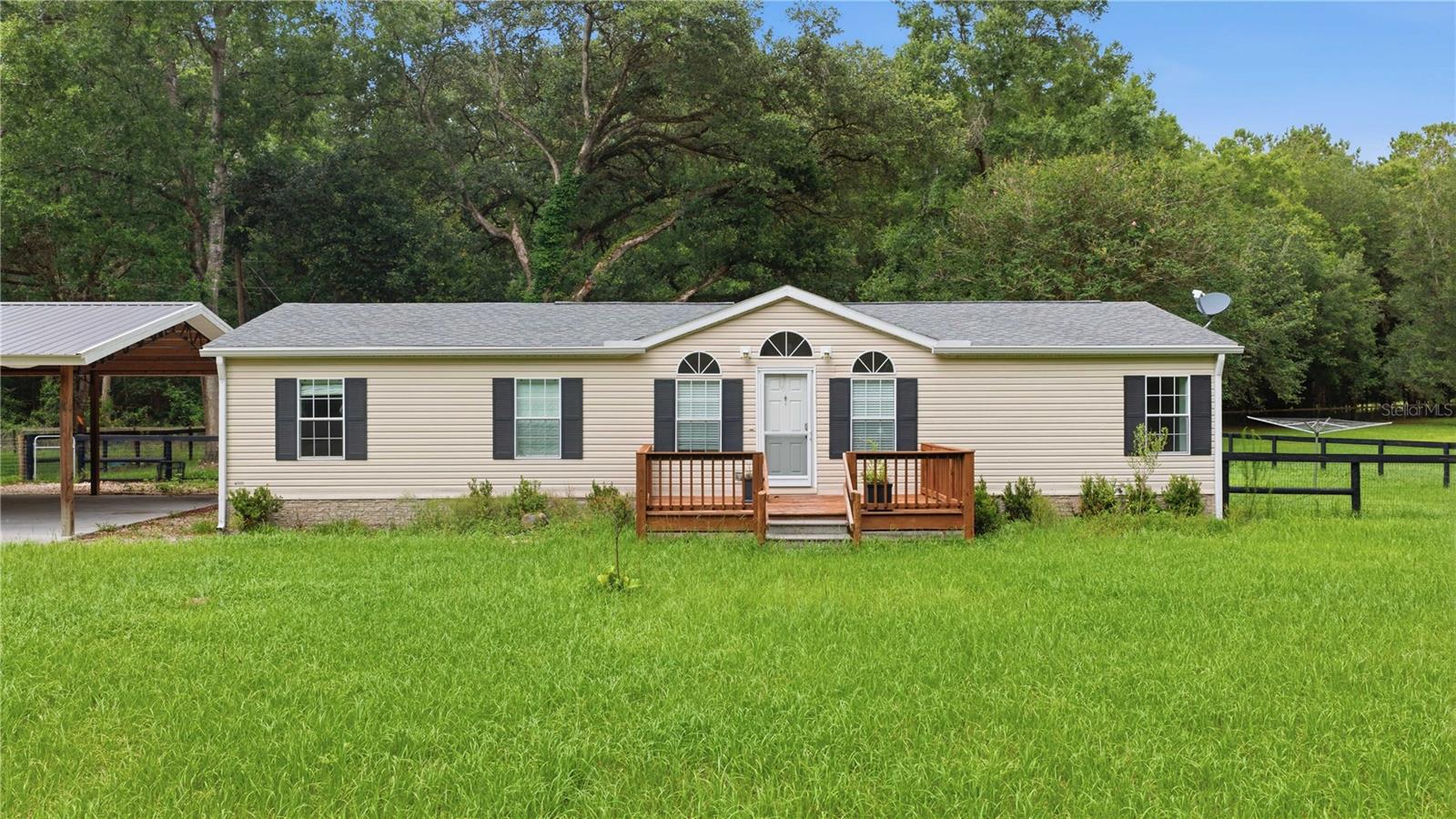 Motivated Seller! Welcome to a 5-acre mini farm in Horse Capital of the World! This bright 3-bedroom, 2-bath home features a split floor plan, spacious living room with a dedicated work area, and a large primary suite with walk-in closet and updated bath. The sunny eat-in kitchen offers plenty of cabinet space and opens to a charming deck—perfect for outdoor dining. Enjoy two decks, a large indoor laundry room, and direct access to a beautiful pole barn with two parking spaces (easily converted to stalls) and storage. The fully fenced property includes a paddock, dog yard, and room to expand, with shade trees surrounding lush pasture. Ideally located just 5 minutes from HITS and 15 minutes from World Equestrian Center, this home is close to shopping, dining, and medical. Updates include luxury vinyl flooring, new roof (2021), well pump (2021), water softener, and pole barn (2022). Perfect for enjoying Florida’s outdoor lifestyle year-round!