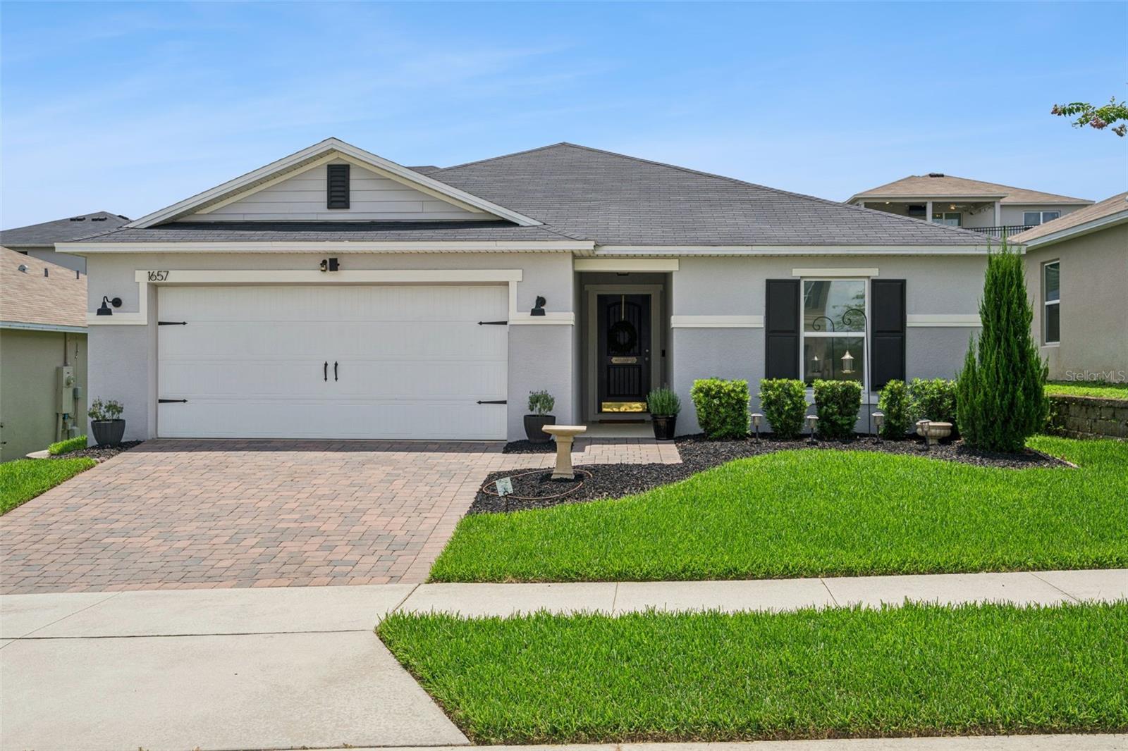 Welcome home to this newer built, meticulously maintained KB Home in the established neighborhood of Wilson Estates. This 4-bedroom, 2-bath home sits behind a paver driveway and manicured landscaping, giving it real curb appeal before you even step inside. It's turnkey ready with no updates needed. The kitchen, made for cooking and connecting, features white cabinetry, marble-look countertops, a subway tile backsplash, and newer stainless-steel appliances. The gold pendant lighting and fixtures add a subtle, upscale touch without feeling over-the-top. The island offers extra prep and seating space, and a well-organized pantry adds storage most homes in this price range don't have. The living room flows into an open dining area and kitchen, all finished with tile flooring for easy upkeep. Sliding glass doors off the dining space lead straight out to the screened lanai, making indoor-outdoor entertaining an easy transition. The front bedroom makes a great home office or den. Both secondary bedrooms are carpeted and outfitted with remote/dimmable ceiling fans, offering flexible space for family, guests, or hobbies. The primary suite offers generous space with an en-suite bath featuring double vanities and matching gold fixtures that carry the same touch of style throughout the home. Out back, irrigation has been added since the home was built, keeping the lawn lush without extra work. The location is hard to beat: minutes from Clermont's restaurants, shopping, and medical facilities, with quick Turnpike access for an easy commute into Orlando. This Property may be under Audio/Visual Surveillance.