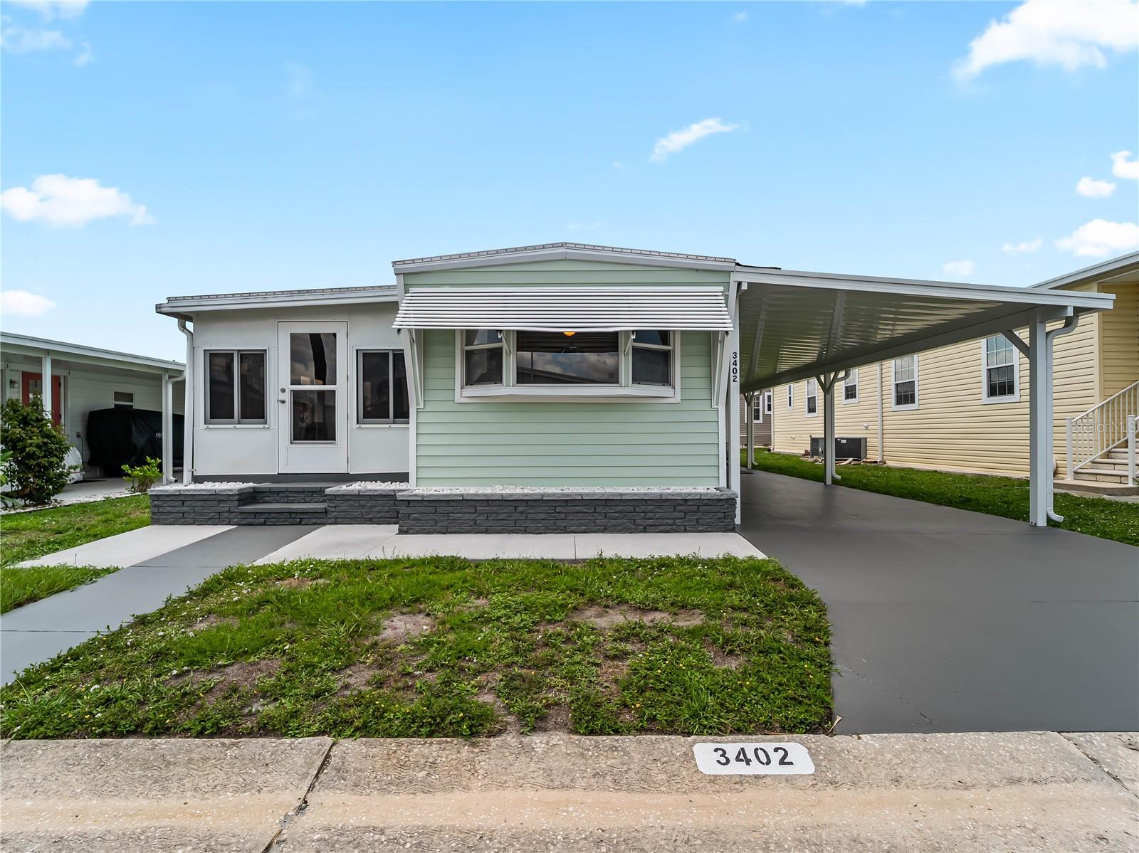Charming, cozy, and move-in ready in the highly desirable 55+ gated community of Oakwood Manor, the ONLY resident-owned park within Sarasota city limits—meaning NO LOT RENT! This delightful FULLY FURNISHED 2-bedroom, 2-bath bungalow-style home is proof that great things come in the perfect-sized package. Thoughtfully updated with quality improvements throughout, this home offers a desirable split-bedroom floor plan, abundant natural light, exceptional storage, and an inviting open-concept design. The added space of the living room push-out creates the perfect area for additional living or dining space, enhancing both comfort and functionality. The beautifully updated kitchen is designed for both functionality and style, featuring a built-in cooktop, built-in oven, overhead microwave, new refrigerator, garbage disposal, and ample cabinetry—making the most of every inch of space. The spacious front guest bedroom is highlighted by a large bay window that fills the room with natural light and is complimented by an en-suite bathroom and indoor laundry with stackable washer and dryer. A fully enclosed Florida room with newer windows and sliding glass doors provides approximately 120 square feet of additional living or entertaining space and features a convenient pass-through entrance to the front bedroom and guest bath, creating flexibility for guests, hobbies, or a relaxing sitting area. Major improvements provide peace of mind for years to come. Previous updates include vinyl siding, replacement windows, and the main sewer line (2018). Recent renovations include new leveling and support piers (10/2025), all new subflooring throughout the home, including the Florida room (10/2025), fresh interior paint, luxury vinyl plank flooring throughout the main living areas, and all new carpet in both bedrooms (11/2025), a complete new TPO roofover and new carport with additional tie-downs rated up to 150 mph (2/2026), new HVAC system, electrical panel, and meter base (3/2026), a new rear concrete patio (4/2026), and a newly constructed framed, vinyl-sided storage shed (6/2026).
Oakwood Manor is a beautifully maintained, gated 90-acre community offering an exceptional Florida lifestyle with a low $210/month maintenance fee, which includes lawn care, cable TV, access to the heated pool and spa, clubhouse amenities, and more. Residents enjoy a spacious clubhouse with a fitness room, library, billiards, commercial kitchen, event hall, stage, dance floor, and an active social calendar filled with year-round activities, clubs, shuffleboard, putt-putt, and community events. Ideally located adjacent to the Legacy Trail and Sarasota's city-managed pickleball courts. Oakwood Manor is located nearby downtown Sarasota and the sandy shores of Lido Beach is an easy drive, with convenient access to shopping, dining, Tamiami Trail, and I-75. Please note that Oakwood Manor is an age-restricted community and does not permit pets or motorcycles.