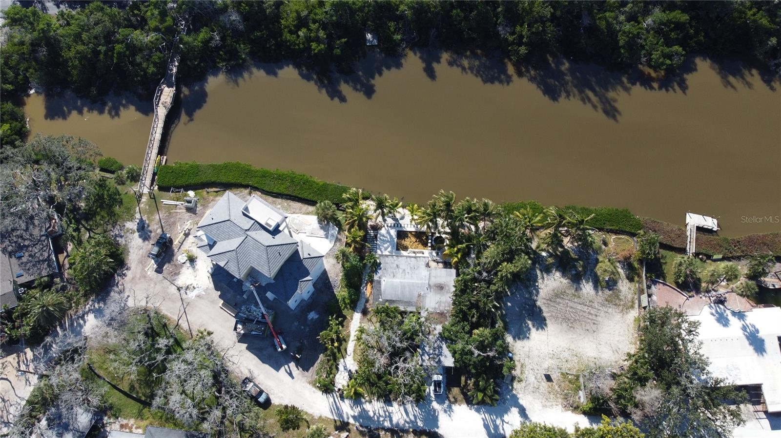 A 2-minute walk across your private footbridge to secluded beach access, this 12,684-square-foot homesite in Heron Lagoon offers a rare opportunity to build a striking modern coastal residence in one of Siesta Key’s most intimate waterfront communities.
To bring the vision to life, custom 3D renderings have been created showcasing an elevated design featuring clean architectural lines, expansive windows, natural stone accents, and seamless indoor-outdoor living. The proposed concept highlights a dramatic two-story façade, covered lanai spaces, and lush tropical landscaping — all thoughtfully designed to complement the tranquil lagoon setting.
The existing $80,000 resort-style pool remains in place and is ideally positioned for integration into a new custom build, offering a head start on creating your private island retreat.
Nestled along a serene waterway, the property provides direct access to kayaking, paddleboarding, fishing, and birdwatching — all just moments from Siesta Key’s world-renowned quartz-crystal beaches. Residents enjoy the rare privilege of private bridge access and a short stroll to beachside cabanas.
The property is offered with the opportunity to build with Yoder Homes, including the option of The Oceana from their exclusive ISLAND SERIES — a thoughtfully designed elevated residence created specifically for Siesta Key’s coastal conditions and sustainability standards. Buyers may also collaborate with the design center to tailor every finish and detail to their personal vision.
With panoramic lagoon views, vibrant Gulf sunsets, and the best of Siesta Key’s boutique shops and coastal dining just minutes away, this property offers the ultimate blank canvas for a one-of-a-kind island oasis.