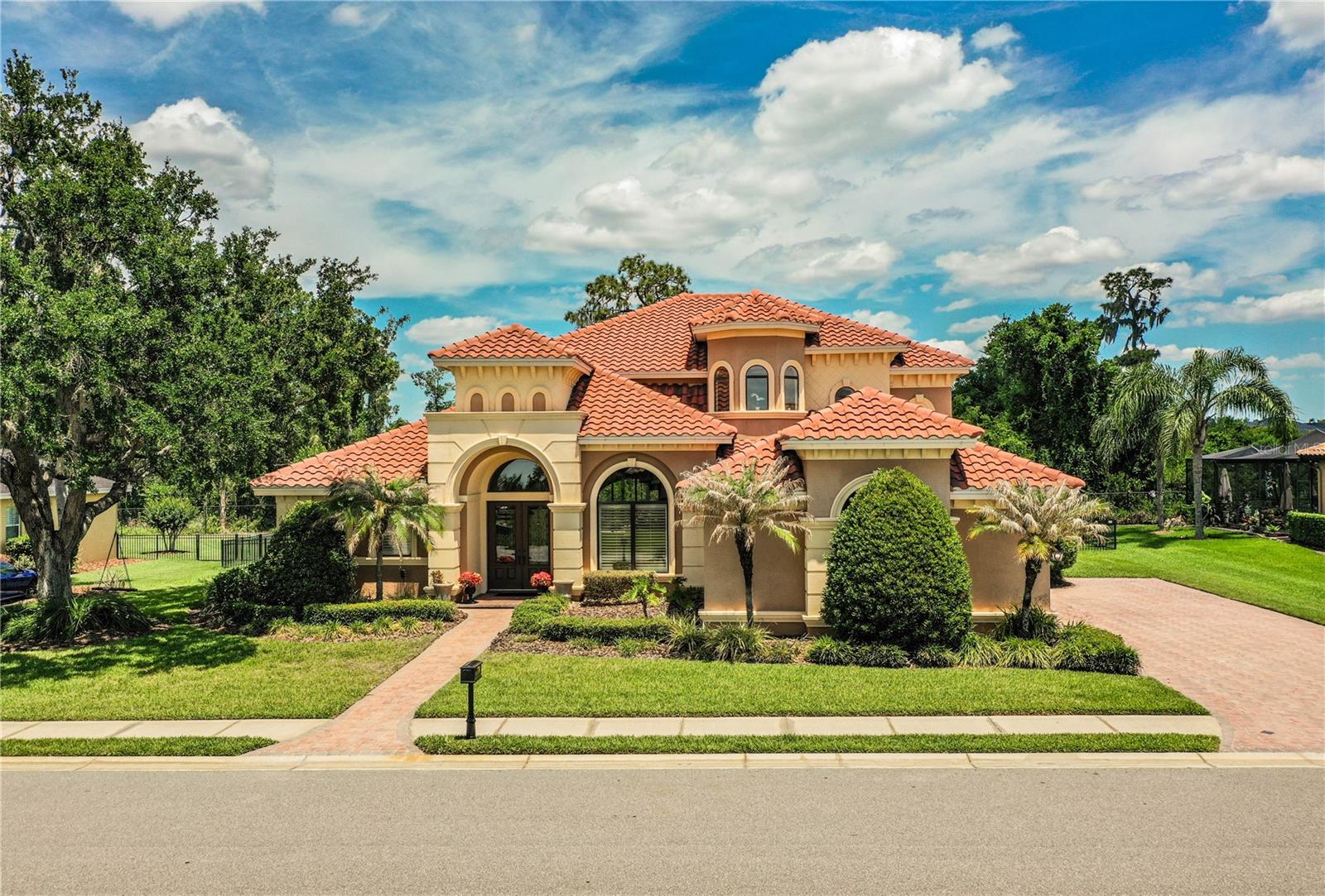 FORMER PARADE OF HOMES MODEL Is now available.   Beautifully awarded former model is just as gorgeous today as it was the day it was featured in the Polk County Parade of Homes.  Loaded with extras and features 5 full bedrooms (5th full bedroom is currently outfitted as a theatre room) 4 full bathrooms, great room floor plan with formal dining room, chefs kitchen, casual dining area and a downstairs master suite with gorgeous spa-like master bathroom, two large walk-in closets and seating area for relaxing in private.  Hardwood flooring in formal areas, porcelain tile in kitchen & bathrooms and ultra-plush carpet in all bedrooms.  Stunningly rich color palette and beautiful millwork throughout.  Upstairs has its own little hidden gem - a small library/study area that is flooded with beautiful natural light.  Also upstairs has a 4th bedroom that can be a private Mother In Law suite with private bathroom opening to a private Juliette balcony overlooking the resort inspired pool below.  And check out the pool area - built for dramatic effect in a timeless style that still looks fresh and unique today with its multiple arcing fountains and outdoor dining/lounging areas.  This gorgeous home tucked well back from the 24/7 guard gated community entrance and backs to a heavily wooded area has been gently lived in and beautifully maintained. Water heater replaced 11/24.  Zoned for some of S. Lakeland's long-time favorite public schools (Scott Lake Elementary, Lakeland Highlands Middle and GJHS).  Eaglebrooke has option open to the public for golf and dining.  Use of the pool and tennis facilities requires a separate membership so be sure to inquire about the various membership plans with the club manager.  Seller offering a home warranty for up to $800.  Seller is a Licensed Real Estate agent. Buyer to verify all sizes are approximate.